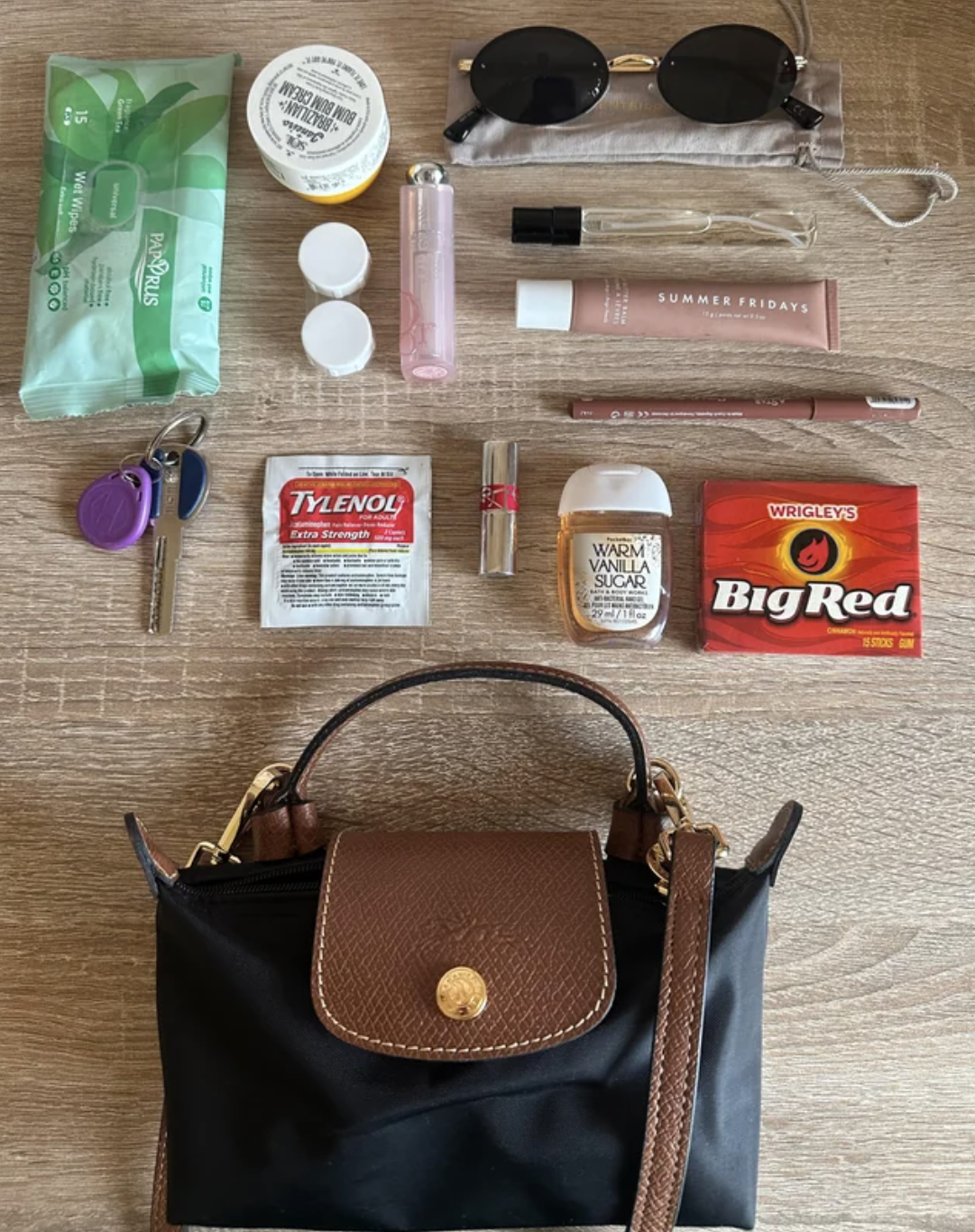 A woman is showing off the contents of her purse