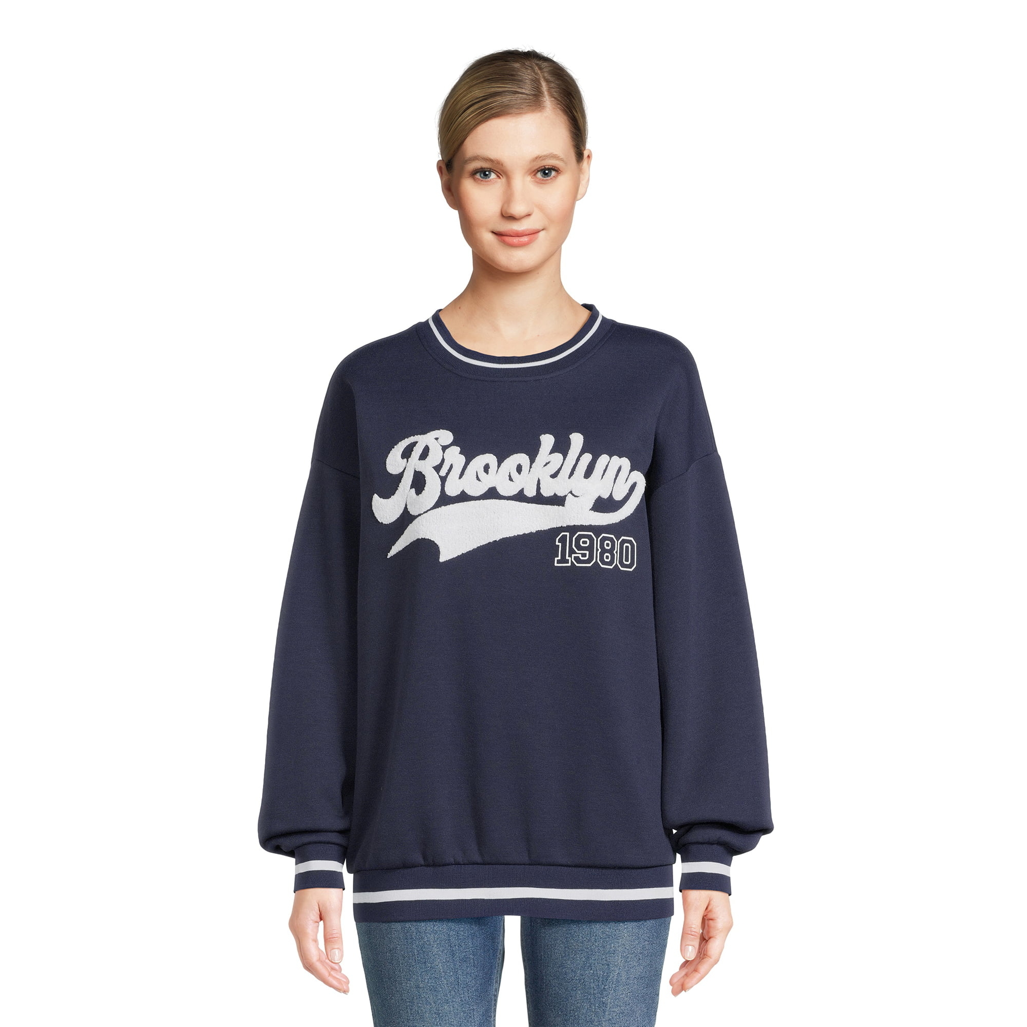 model wearing dark blue sweatshirt with &quot;Brooklyn&quot; on the front