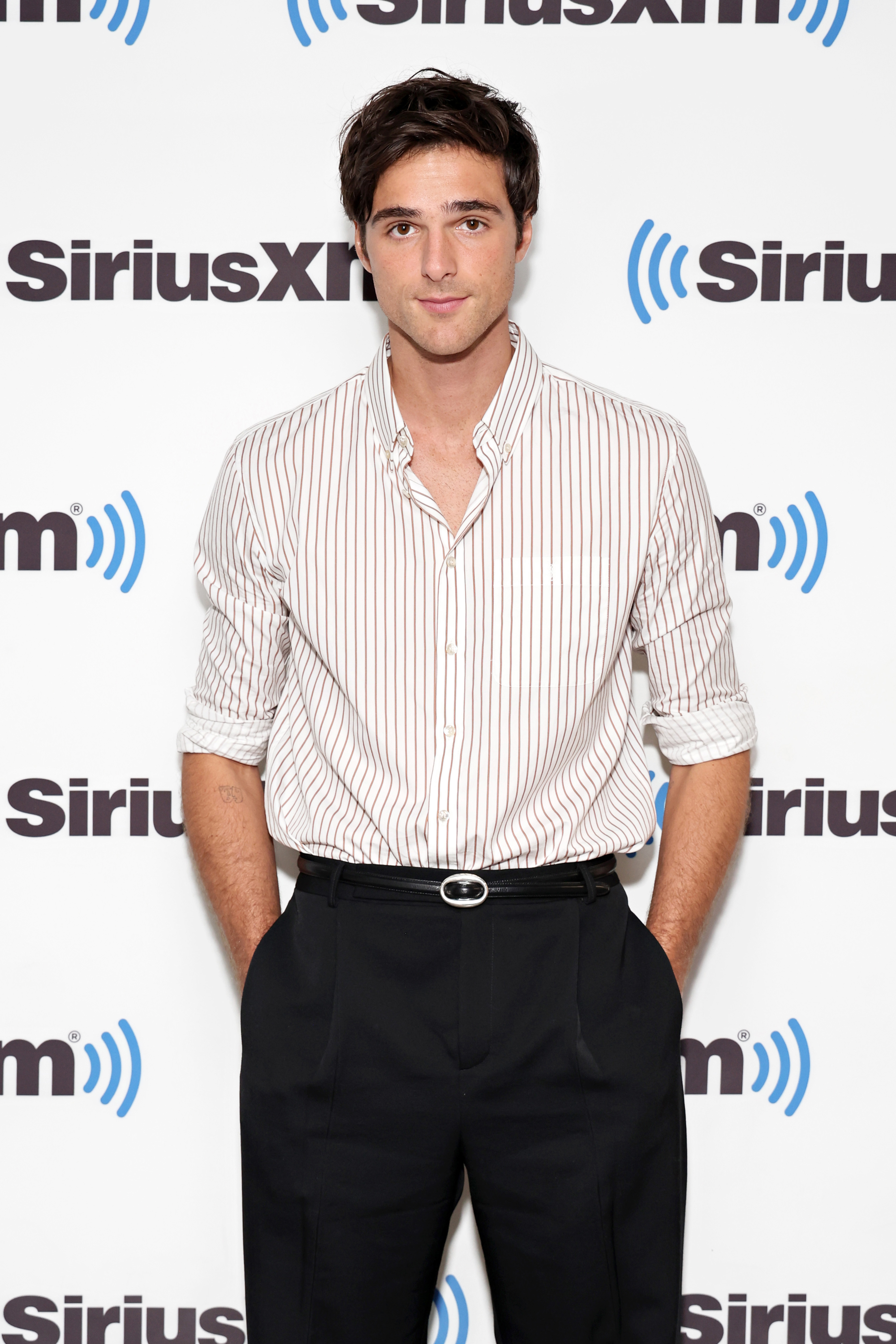 Closeup of Jacob Elordi on the red carpet in a dress shirt and slacks