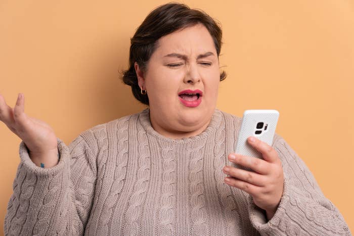 A woman looking flabbergasted at something on her phone