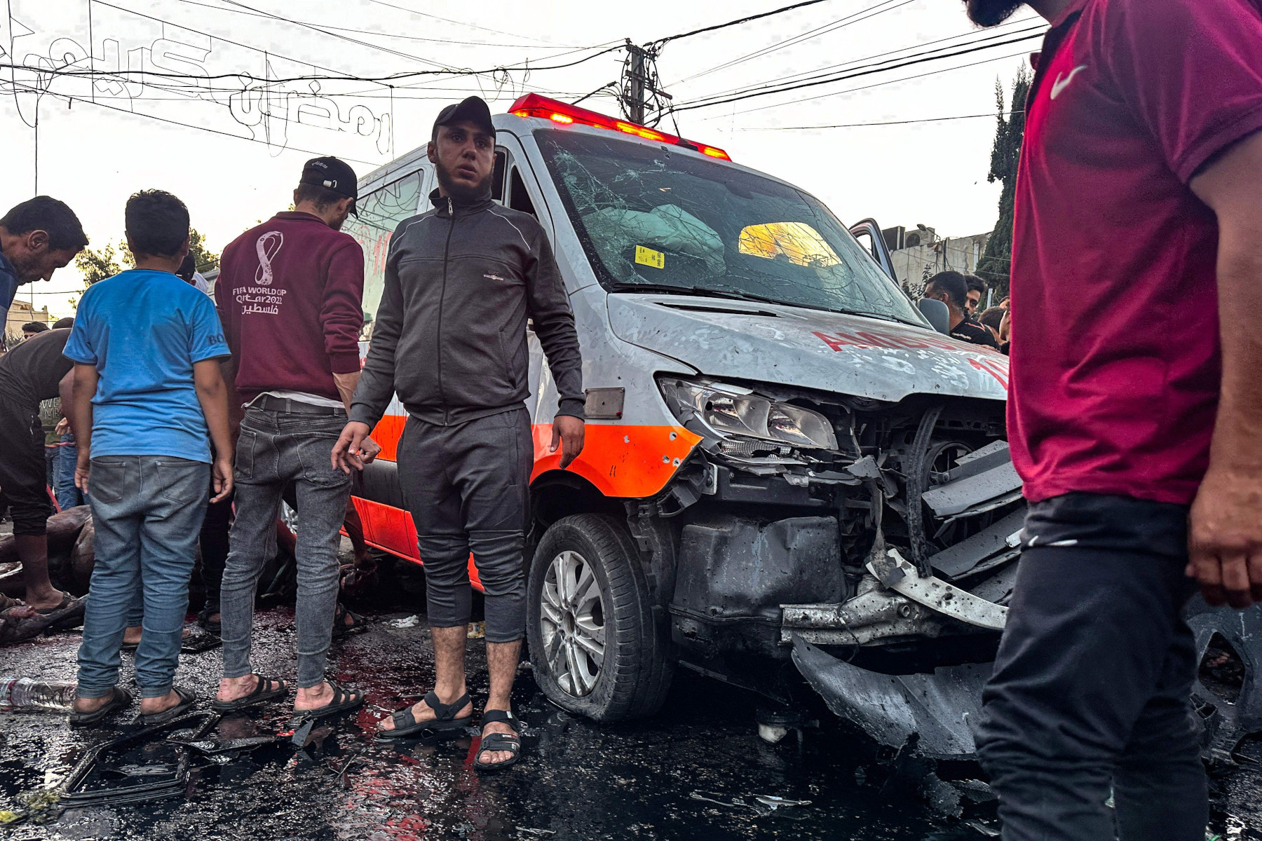 2023年11月3日、ガザ市のアル・シファ病院前で報じられたイスラエルの攻撃で損傷した救急車の周りに集まる人々（AFP＝時事）