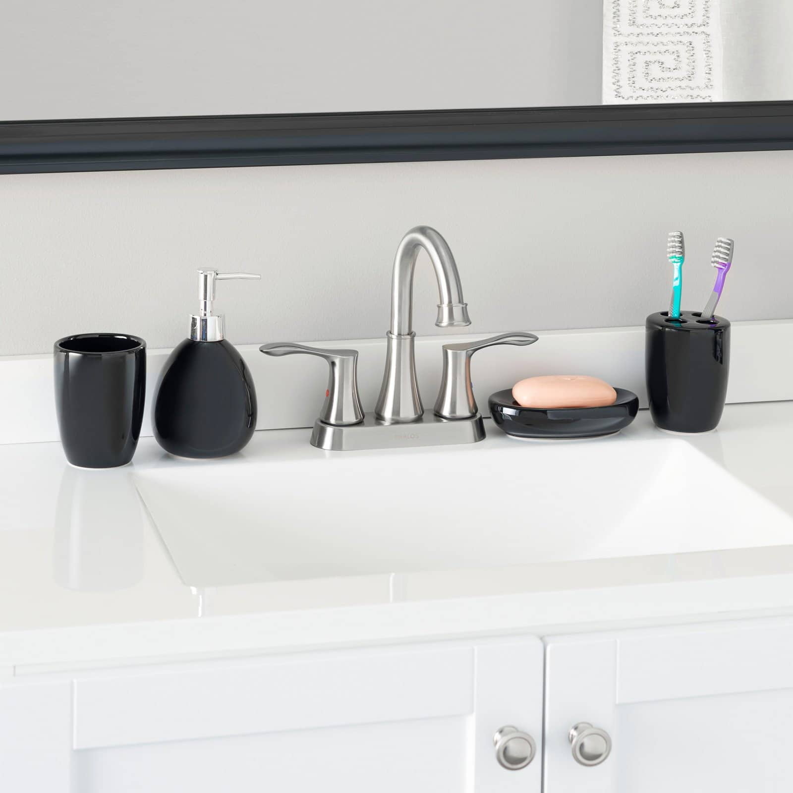 a black ceramic accessory set on a bathroom sink
