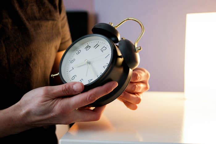 a person holding an alarm clock