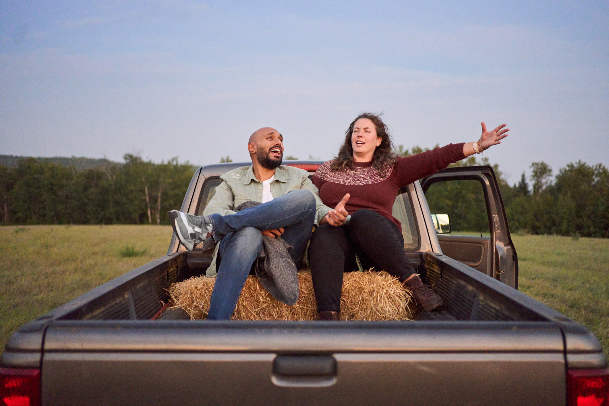 a couple sitting in the back of a truck