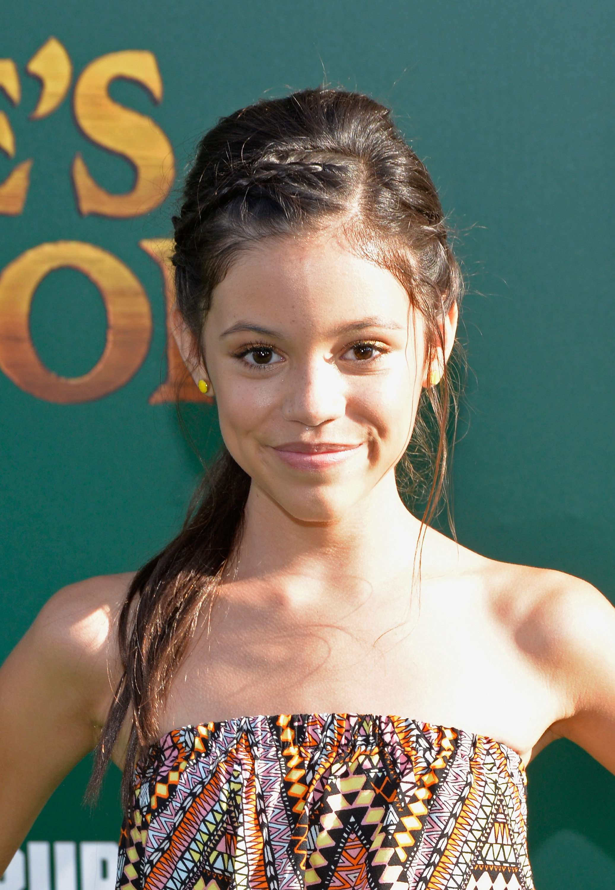 Close-up of Jenna as a child at a media event in a strapless print outfit
