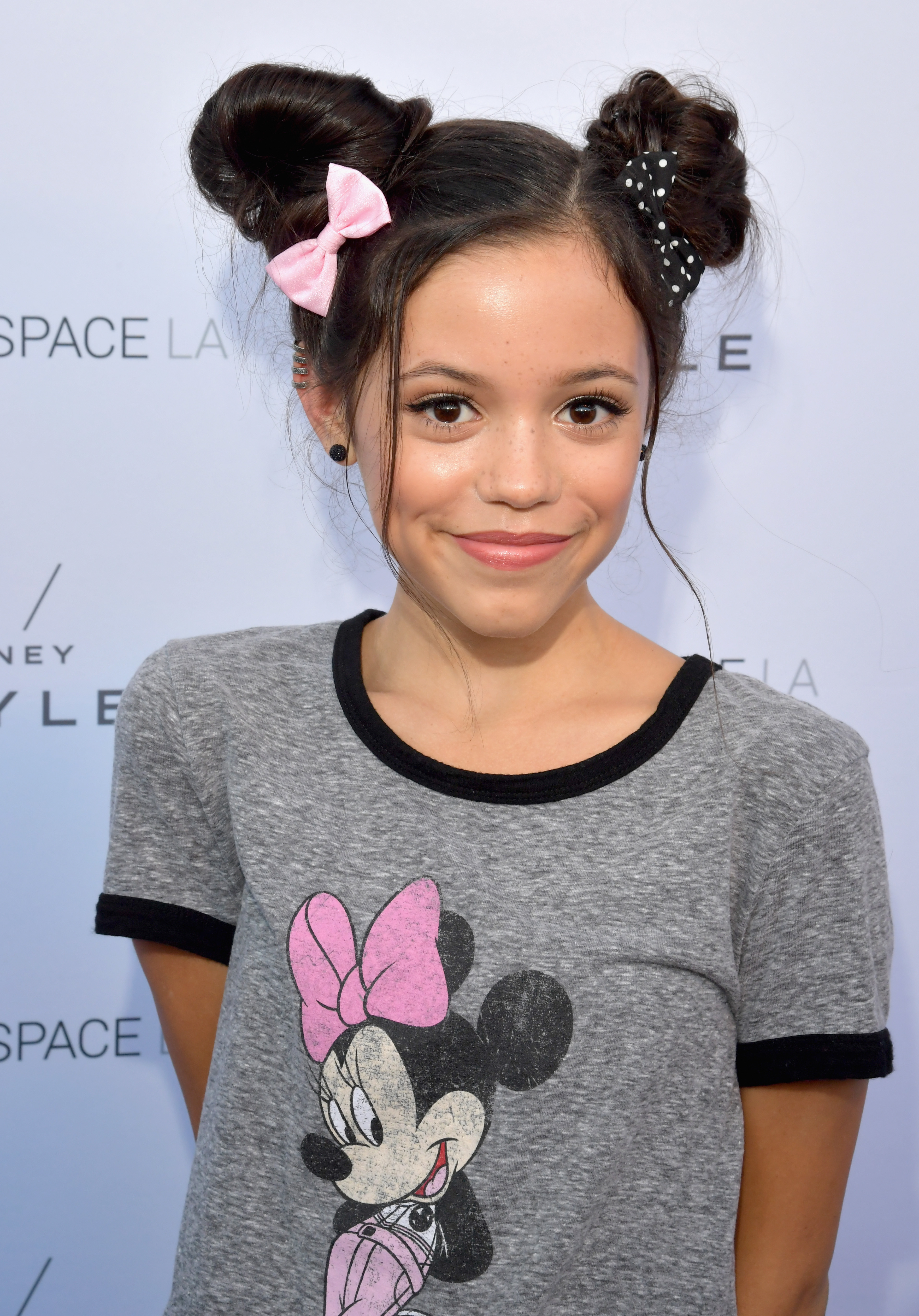 Close-up of Jenna as a child at a media event wearing a Mickey Mouse T-shirt and pigtails with ribbons