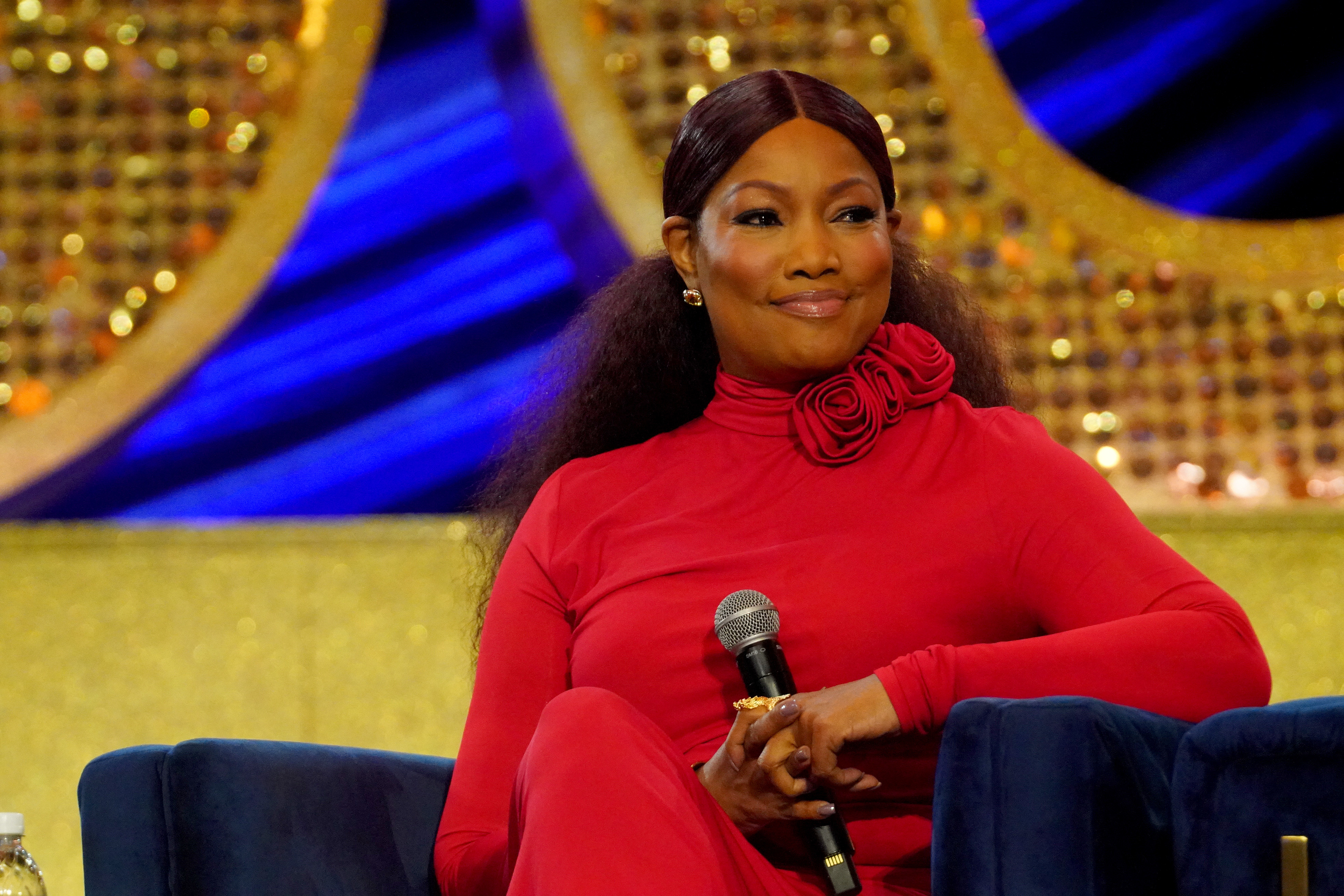 Close-up of Garcelle sitting onstage and smiling