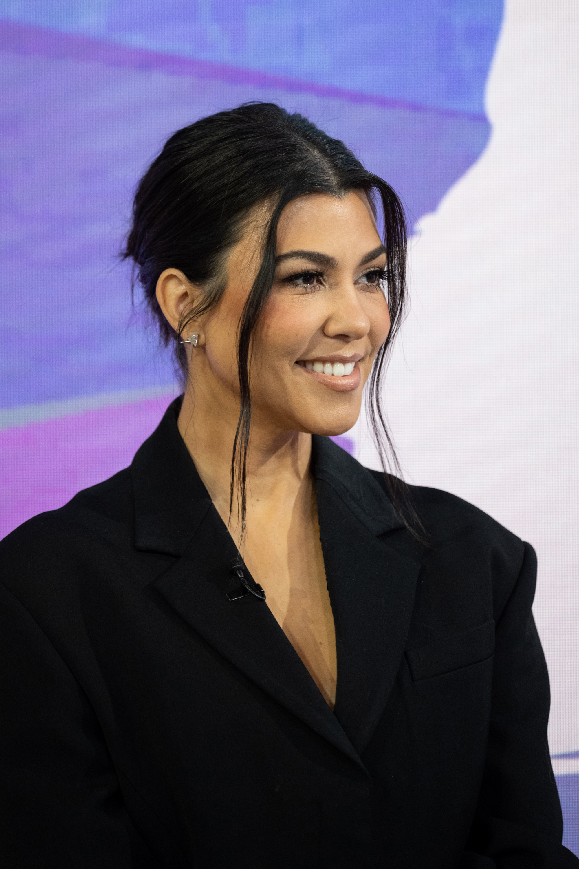Close-up of Kourtney smiling at a media event