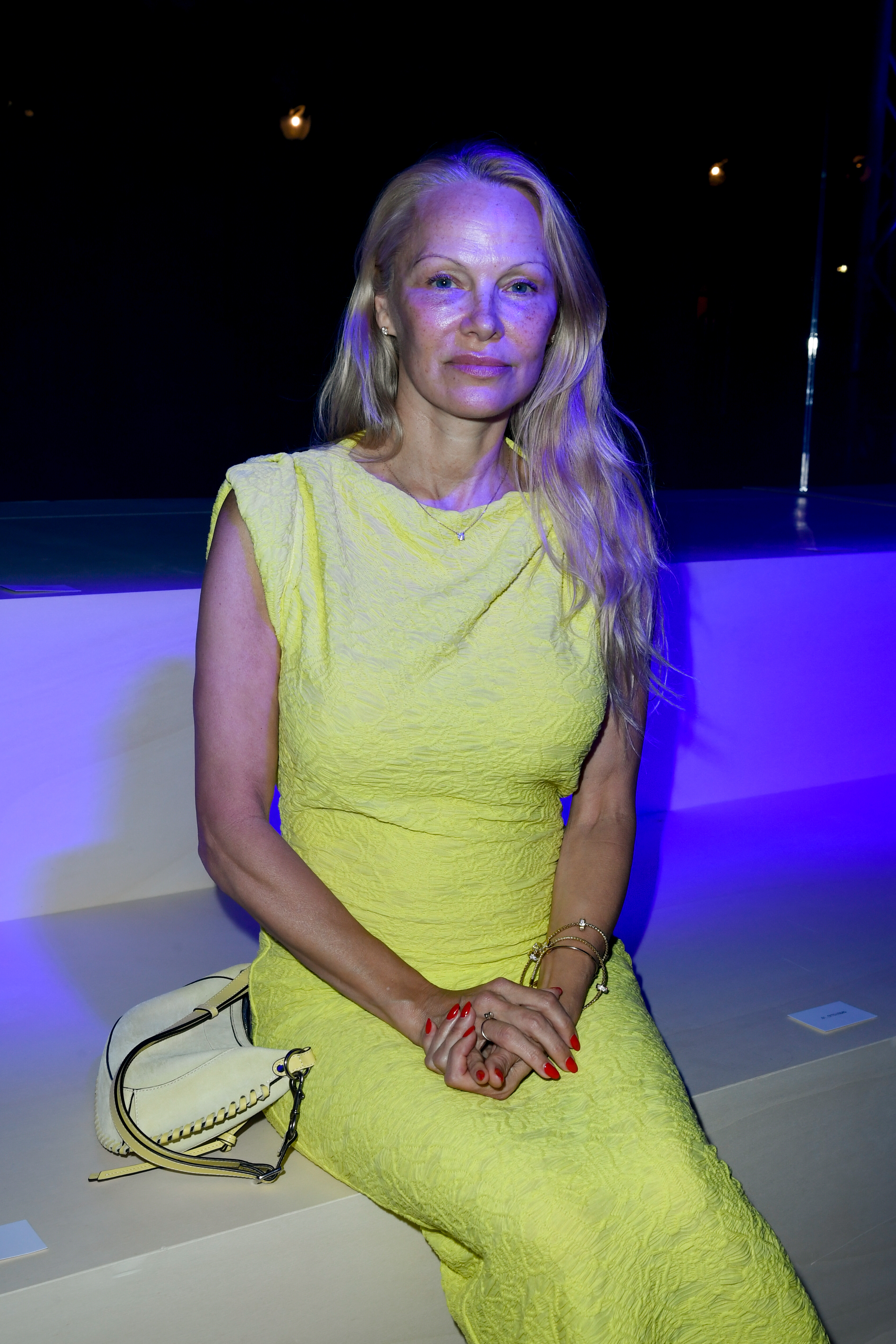 Pamela Anderson sitting at an event