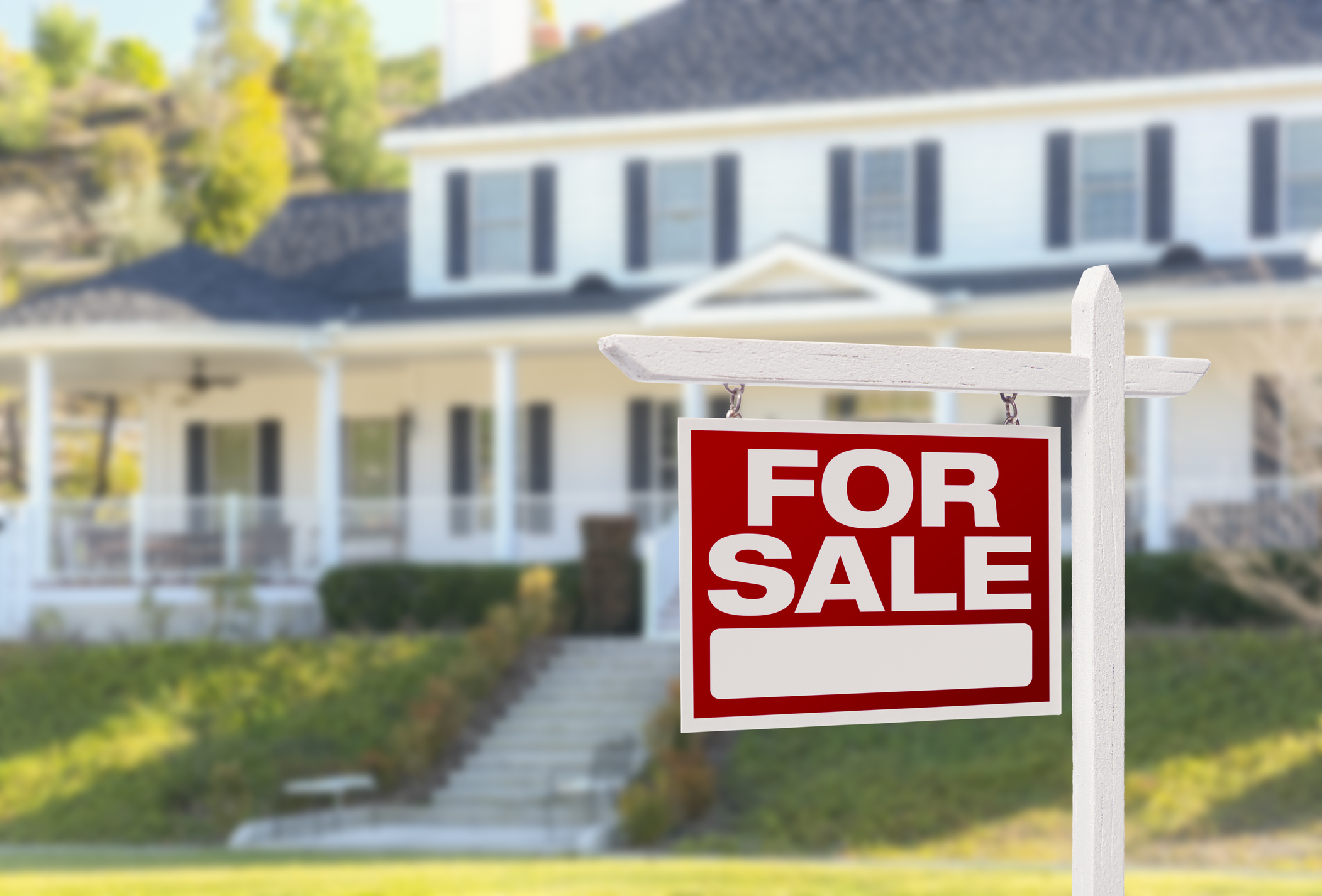 a &quot;for sale&quot; sign in front of a house
