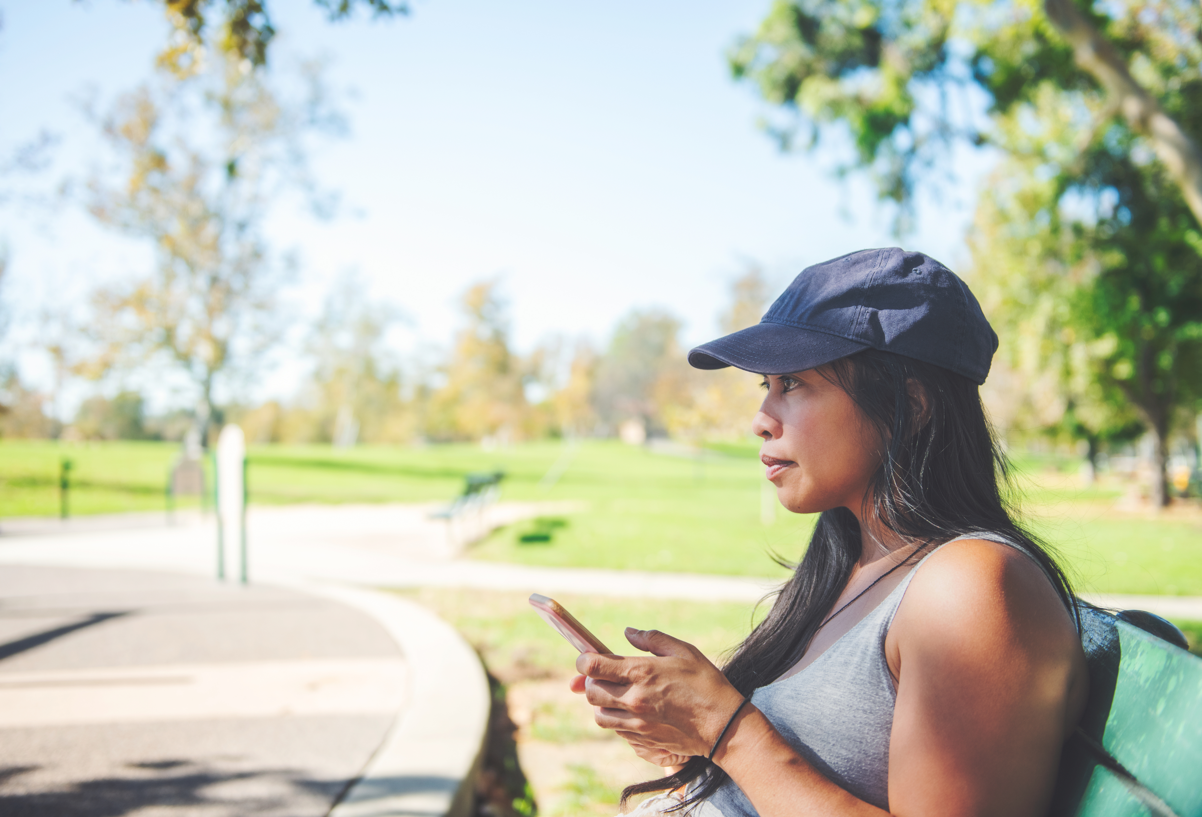 a woman sitting on a bench with a hat on