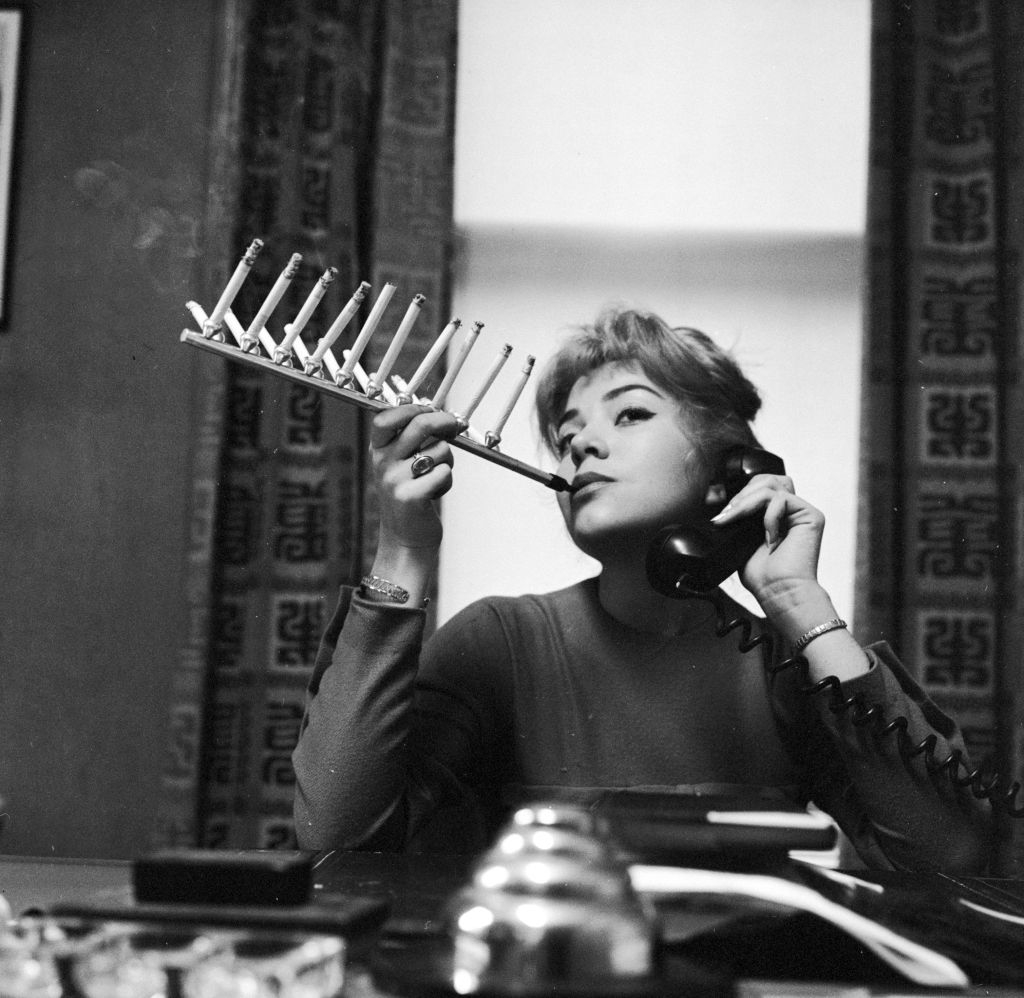 a woman smoking while on the phone