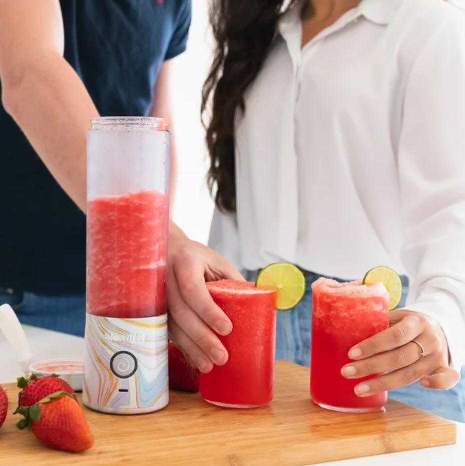 blendjet with strawberry juice with two models holding drinks
