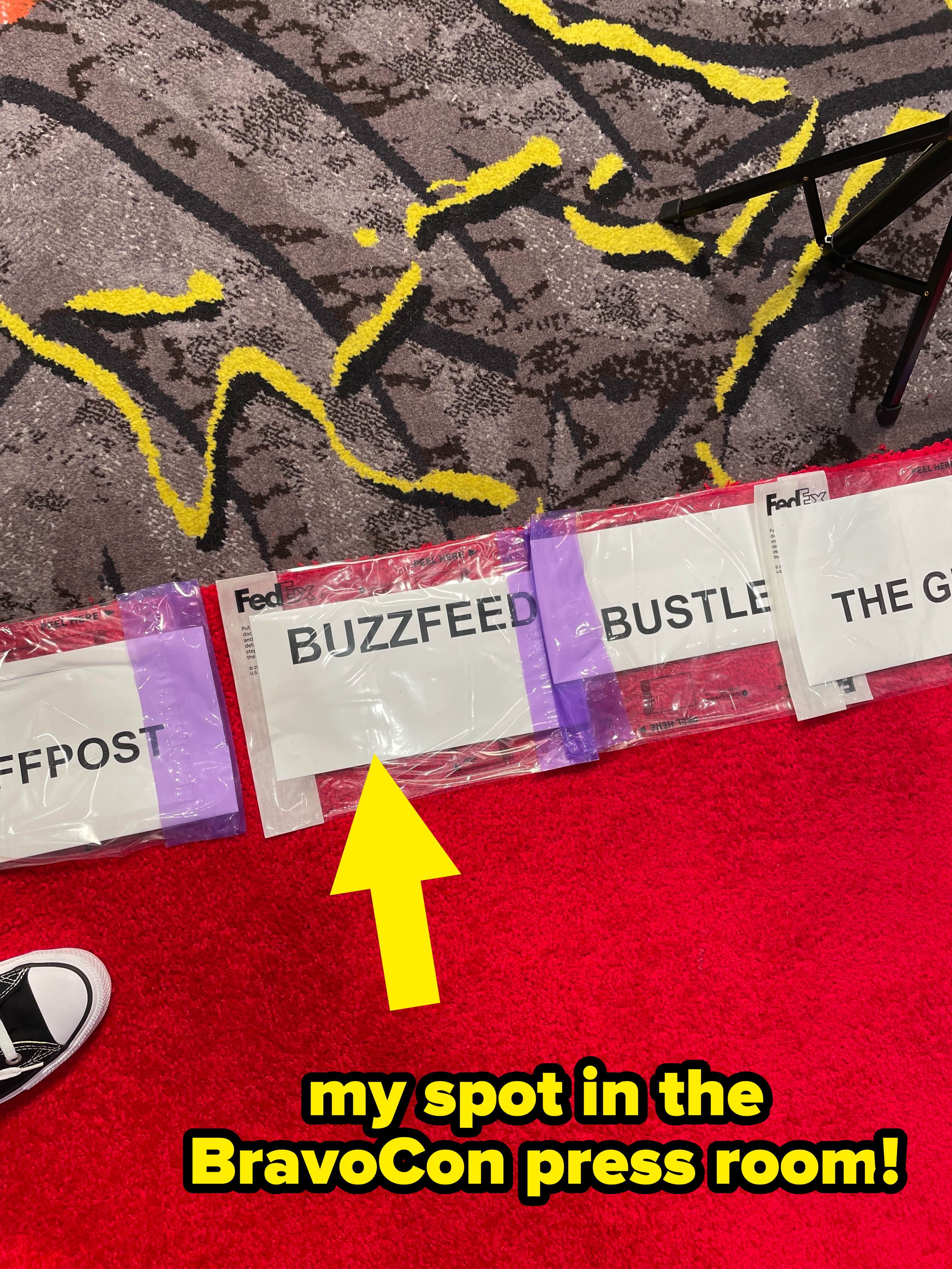A shot of the author&#x27;s feet on the red carpet displaying the &quot;BuzzFeed&quot; press sign