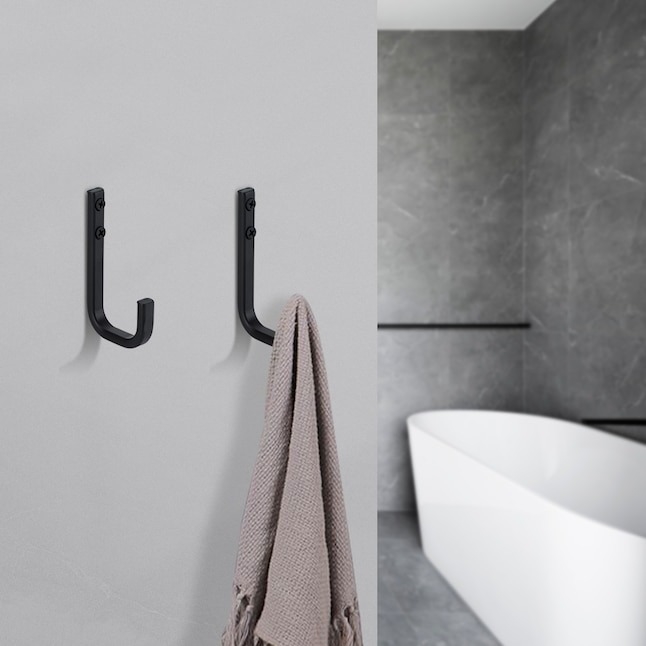 set of black towel hooks with towel next to tub