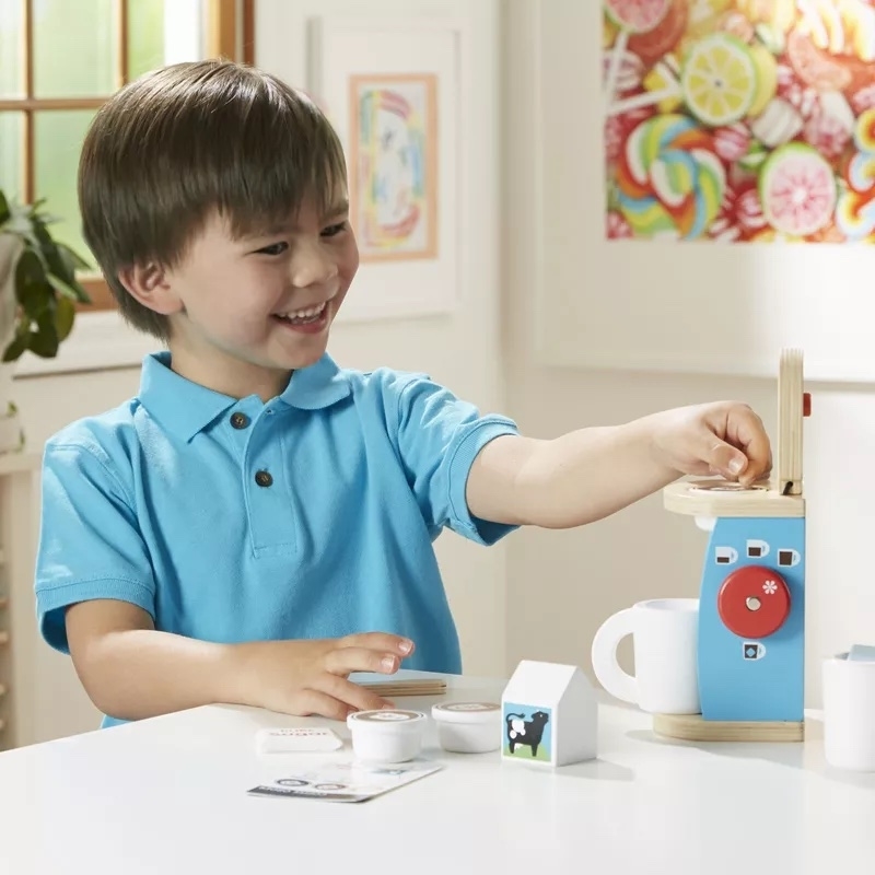 a child plays with the toy coffee maker