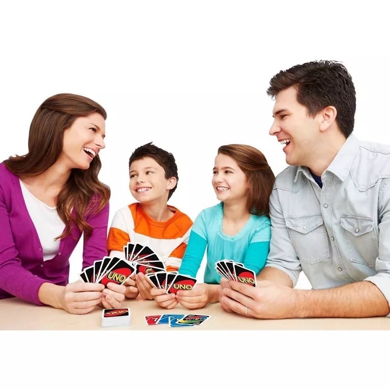 Adults and children play UNO together