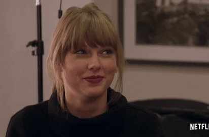 Taylor Swift scrunches her nose with a giggle.