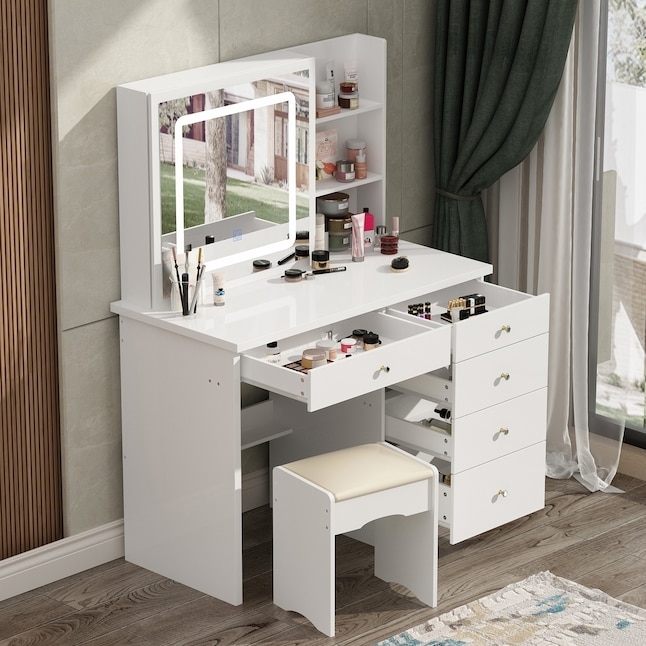 a cosmetics vanity filled with makeup with a few drawers open