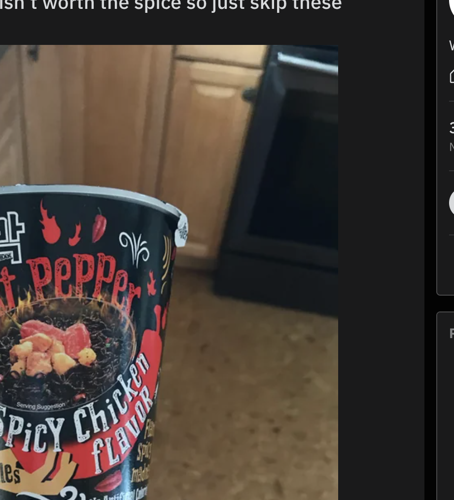 A cup of noodles is being held up to show the ghost pepper flavoring