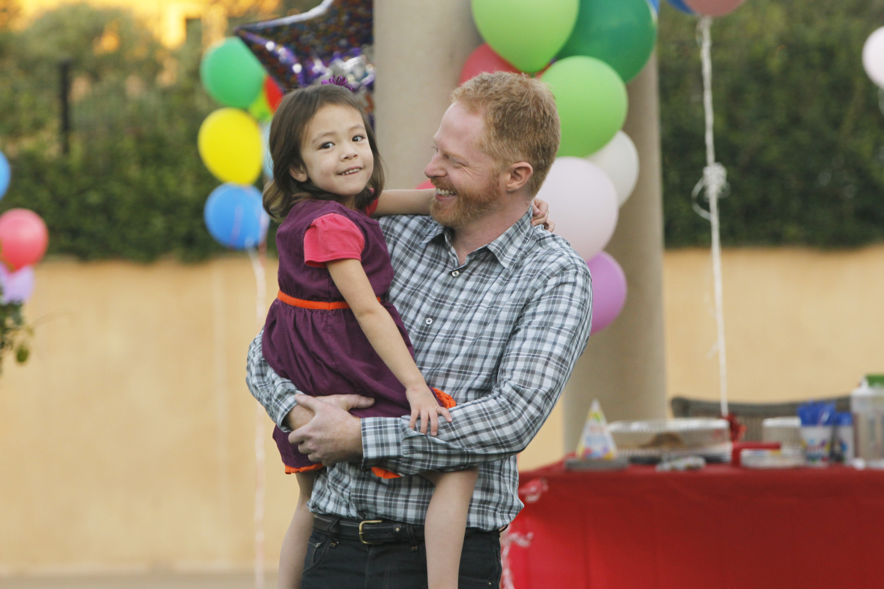 Aubrey and Jesse in a season 3 still from the show in front of a table full of balloons