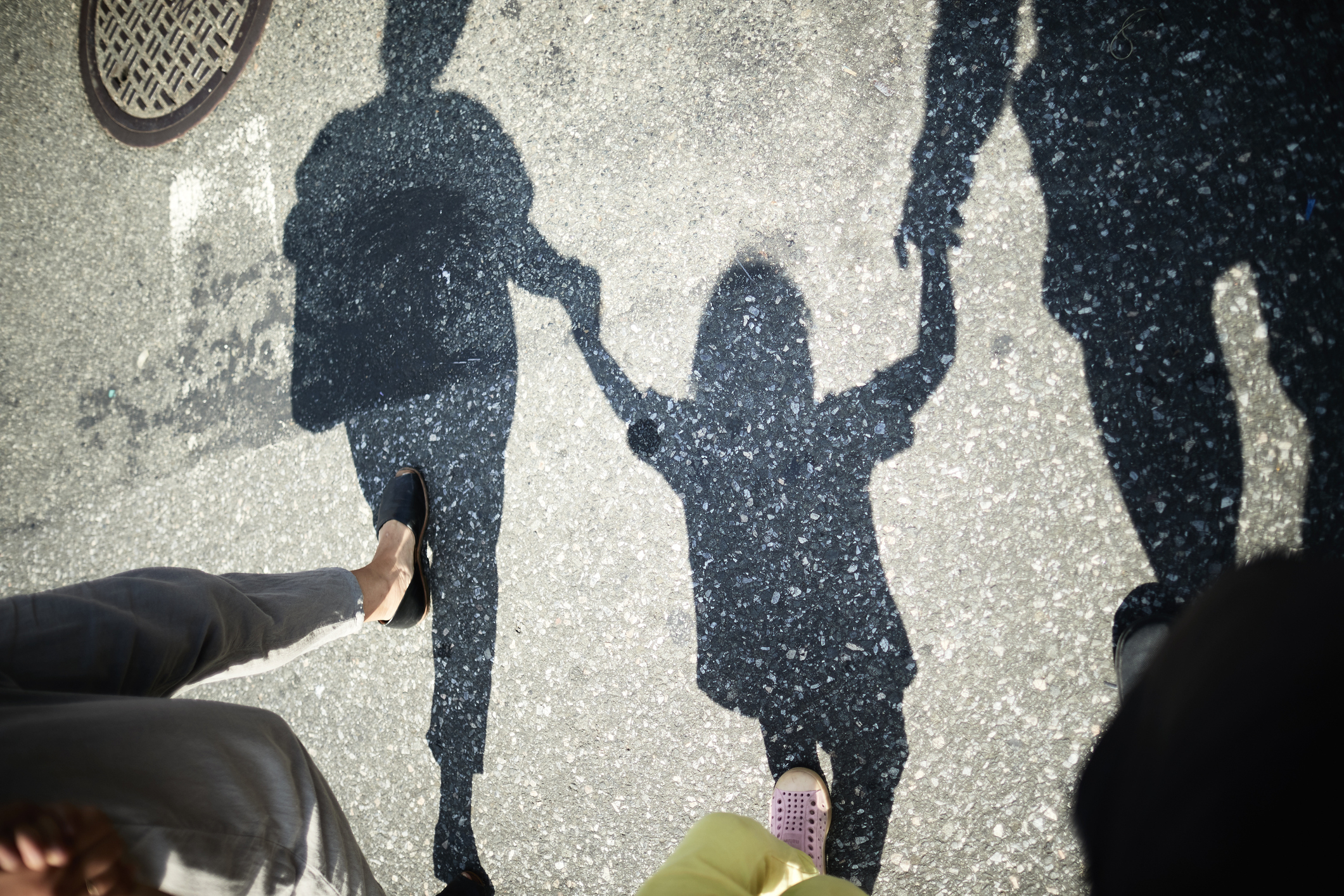 family&#x27;s shadow as they hold hands and walk