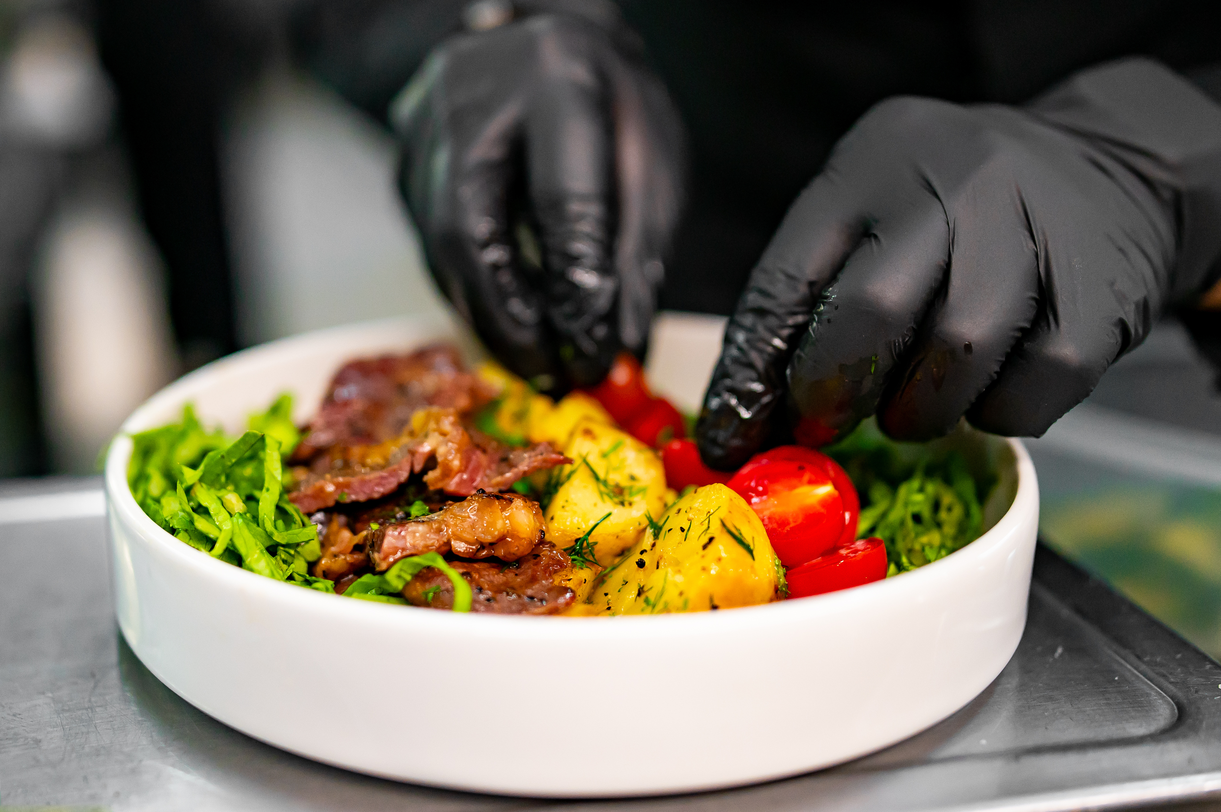 A chef putting together a very bright and beautiful salad