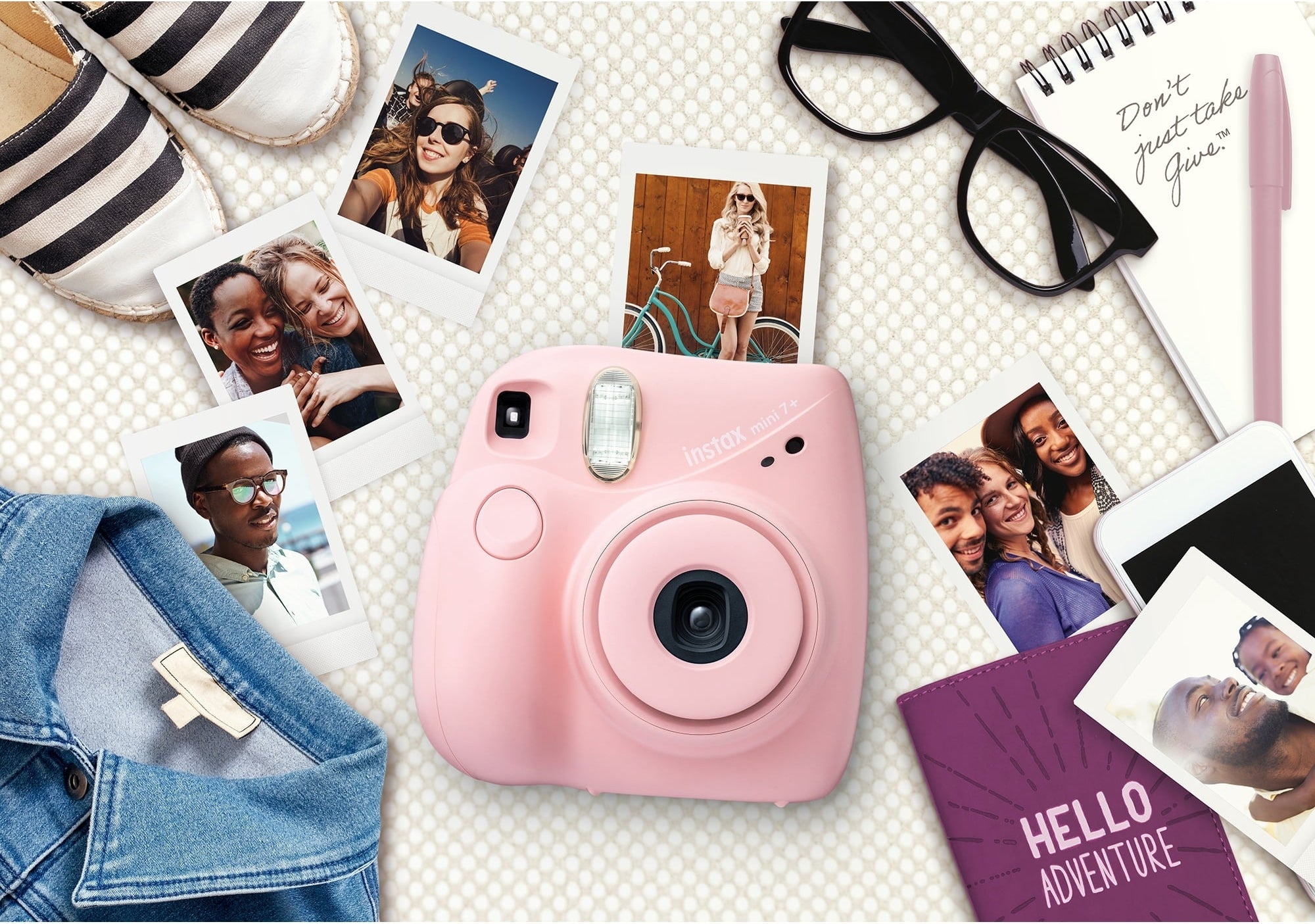 An instant camera surrounded by pictures