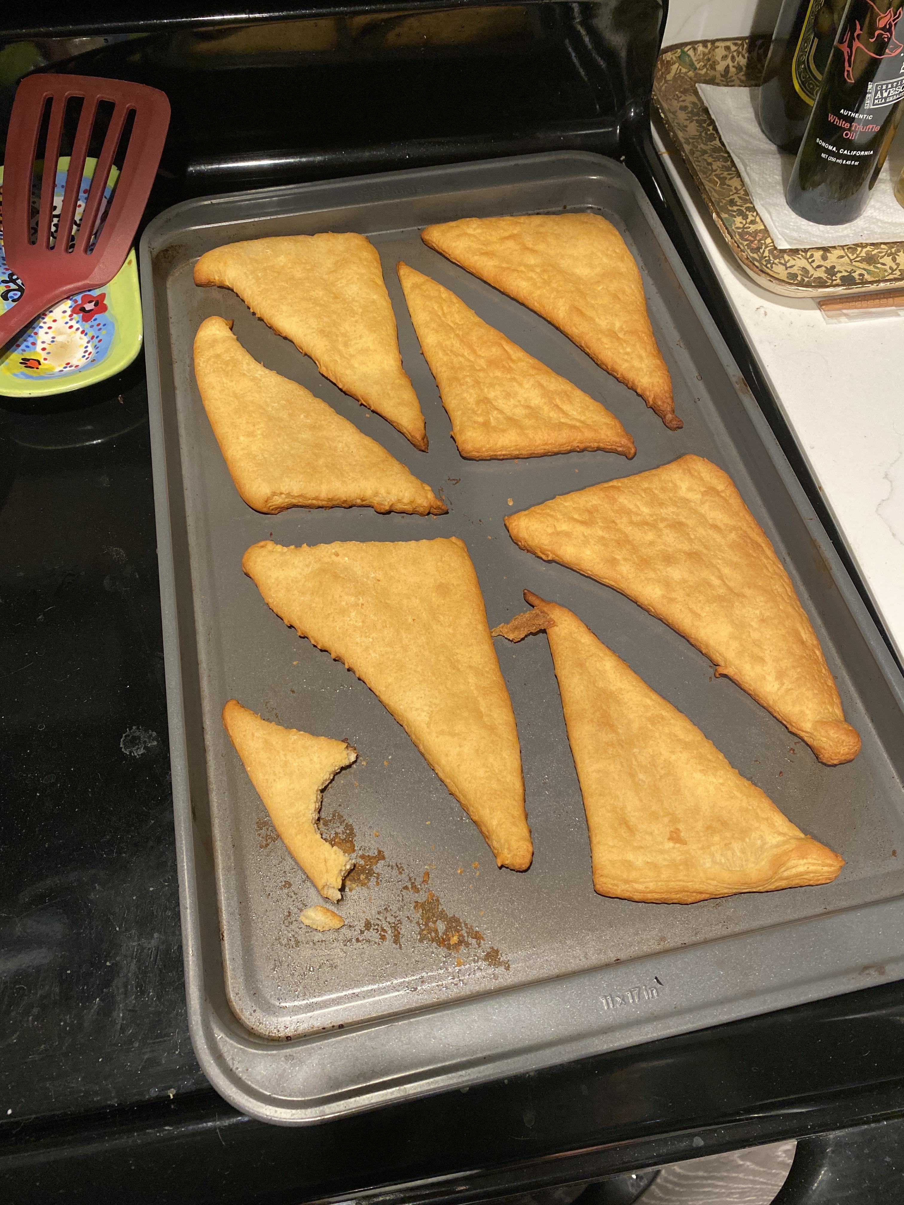 pillsbury croissants, unrolled, laid flat, on a baking sheet coming out baked like flat triangles