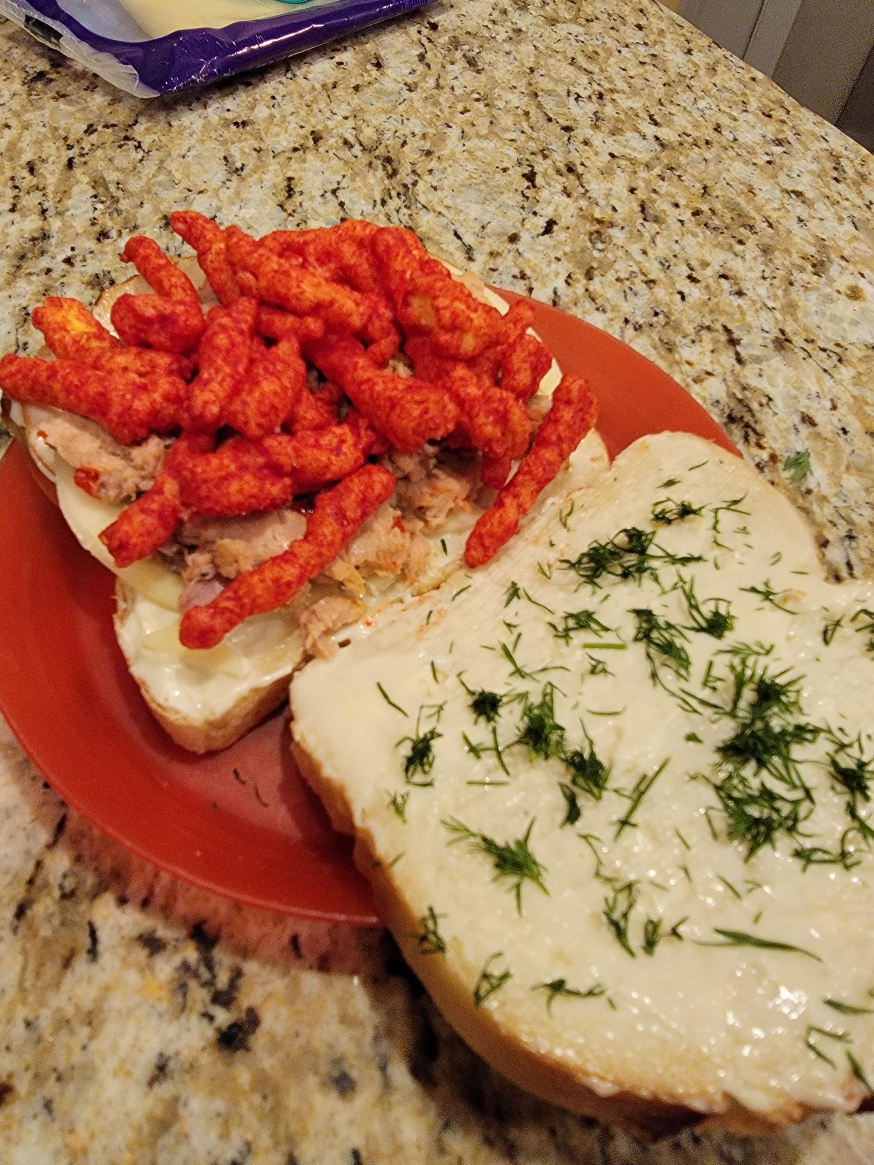 white bread with tuna, hot cheetos, and dill inside