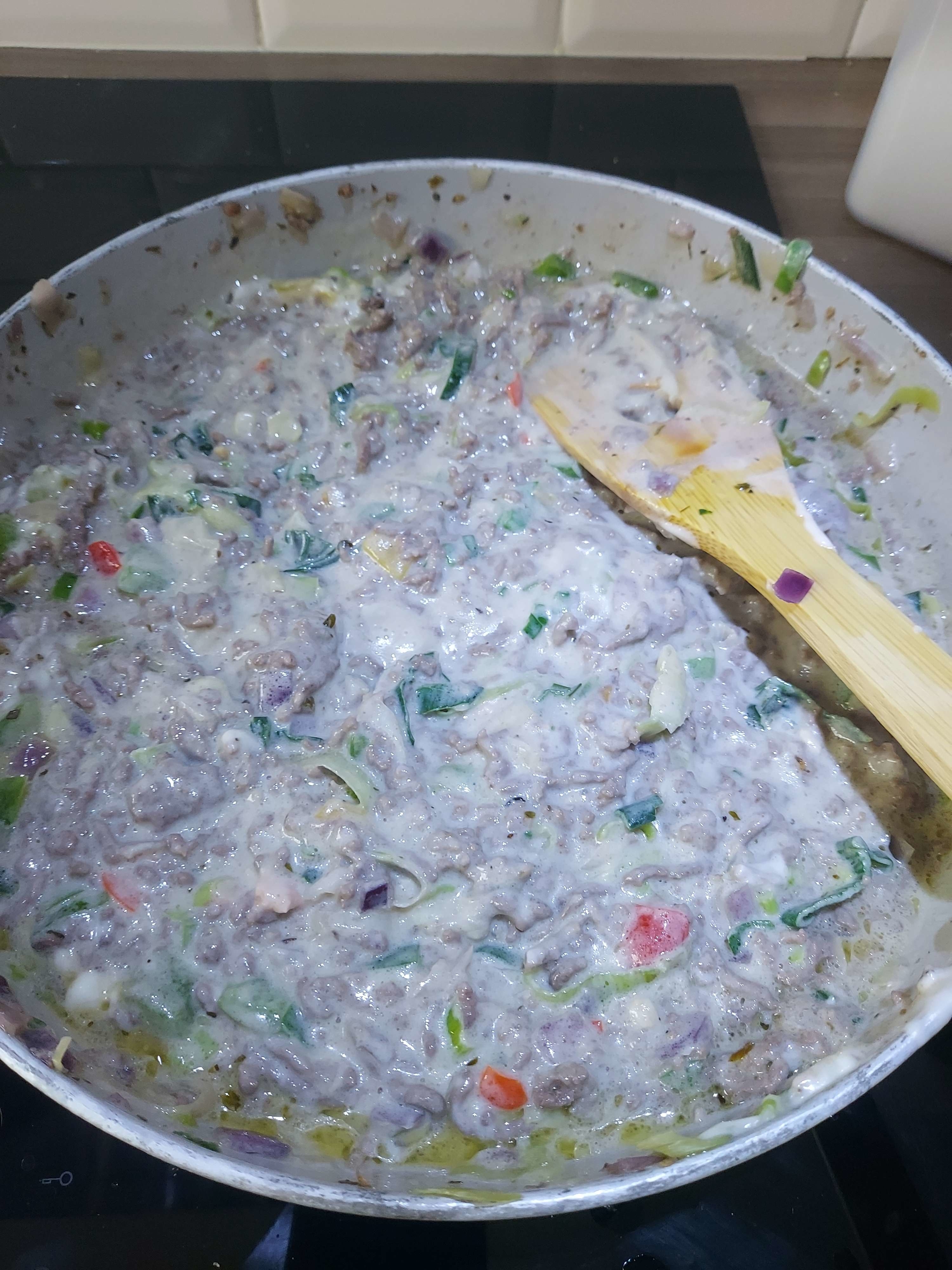 a pot of grey and mushy looking slop with chunks of ground meat and vegetables