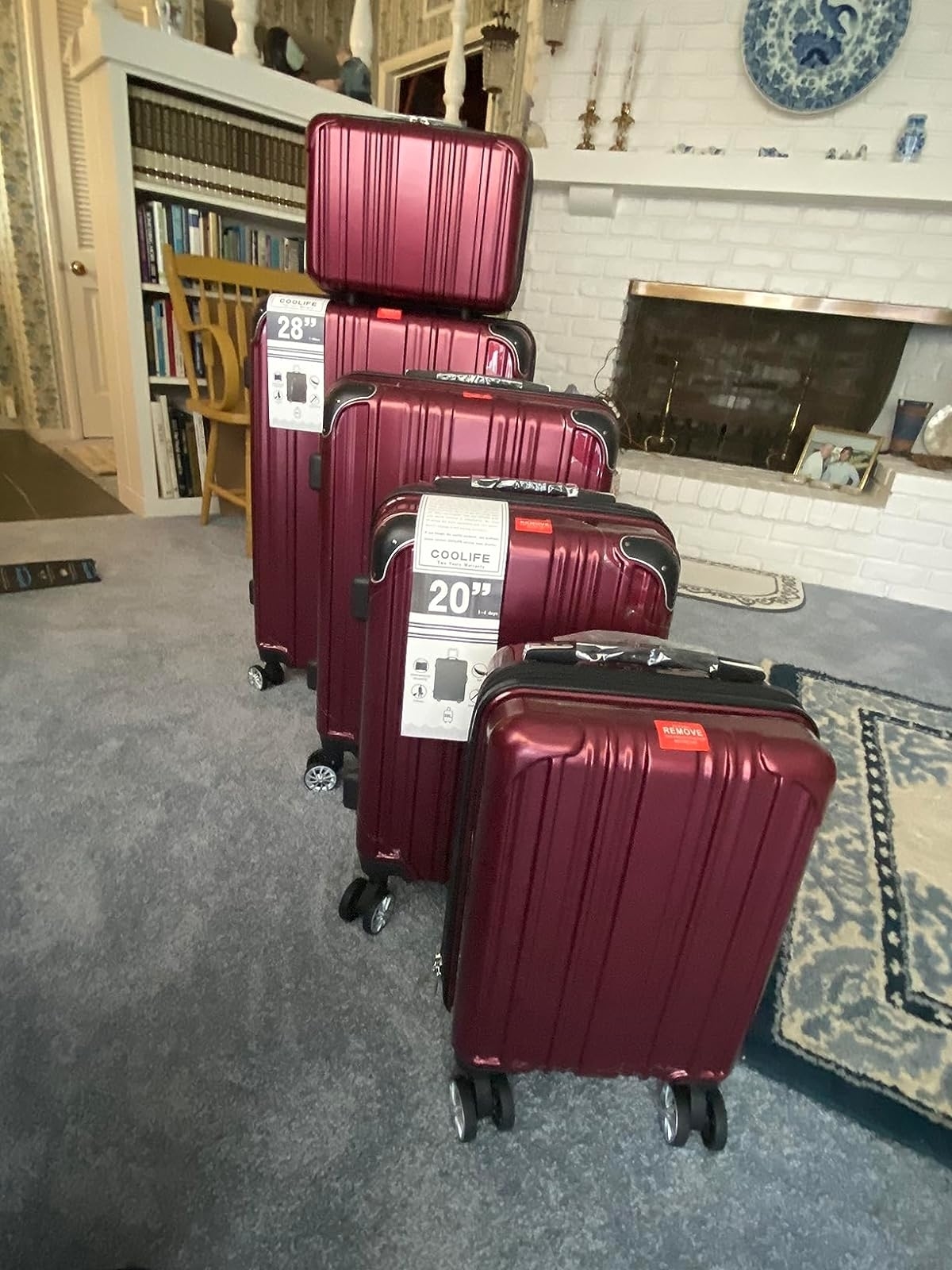 reviewer&#x27;s five red hard shell suitcases in all different sizes with spinner wheels