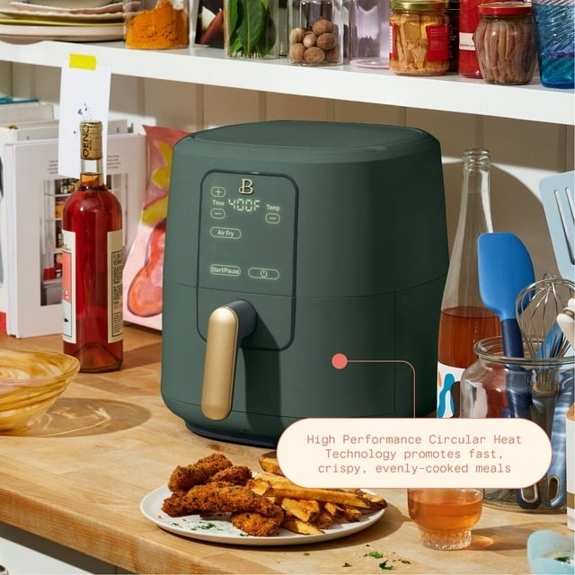 the dark green air fryer on a counter
