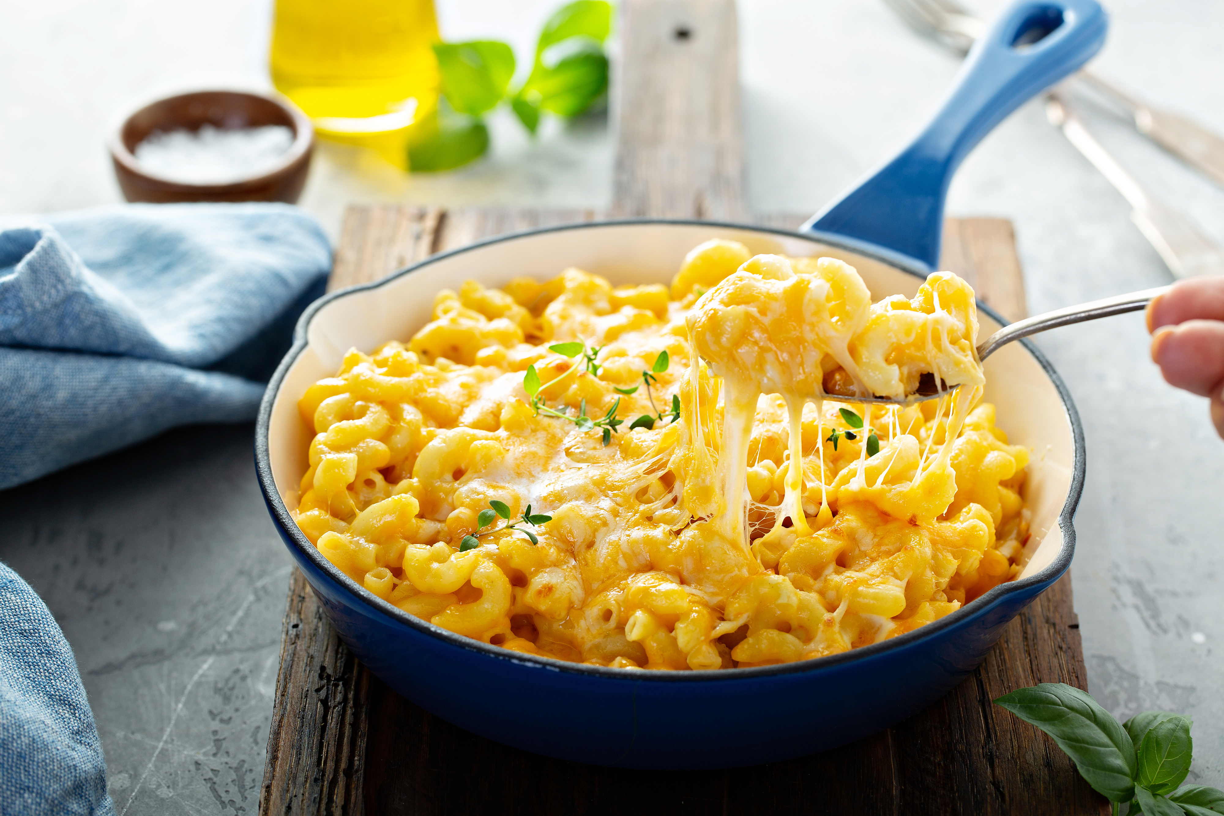 mac and cheese in a skillet being served with a spoon