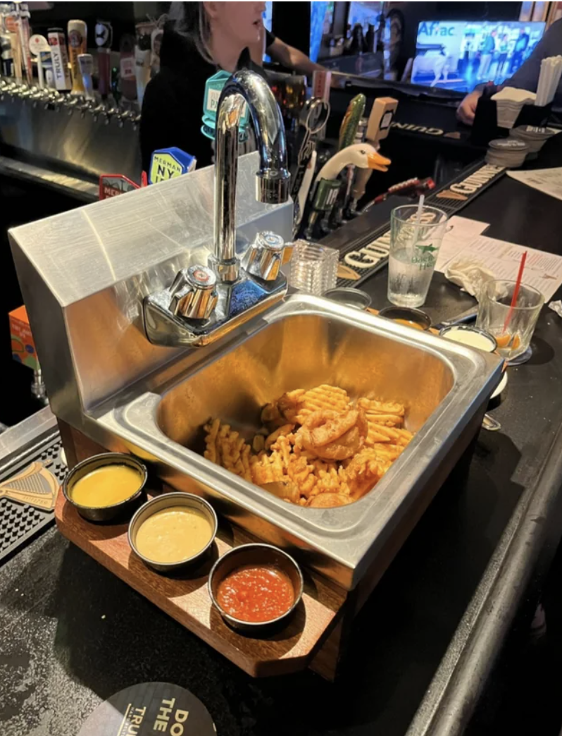 sink with fries inside and condiments on the side