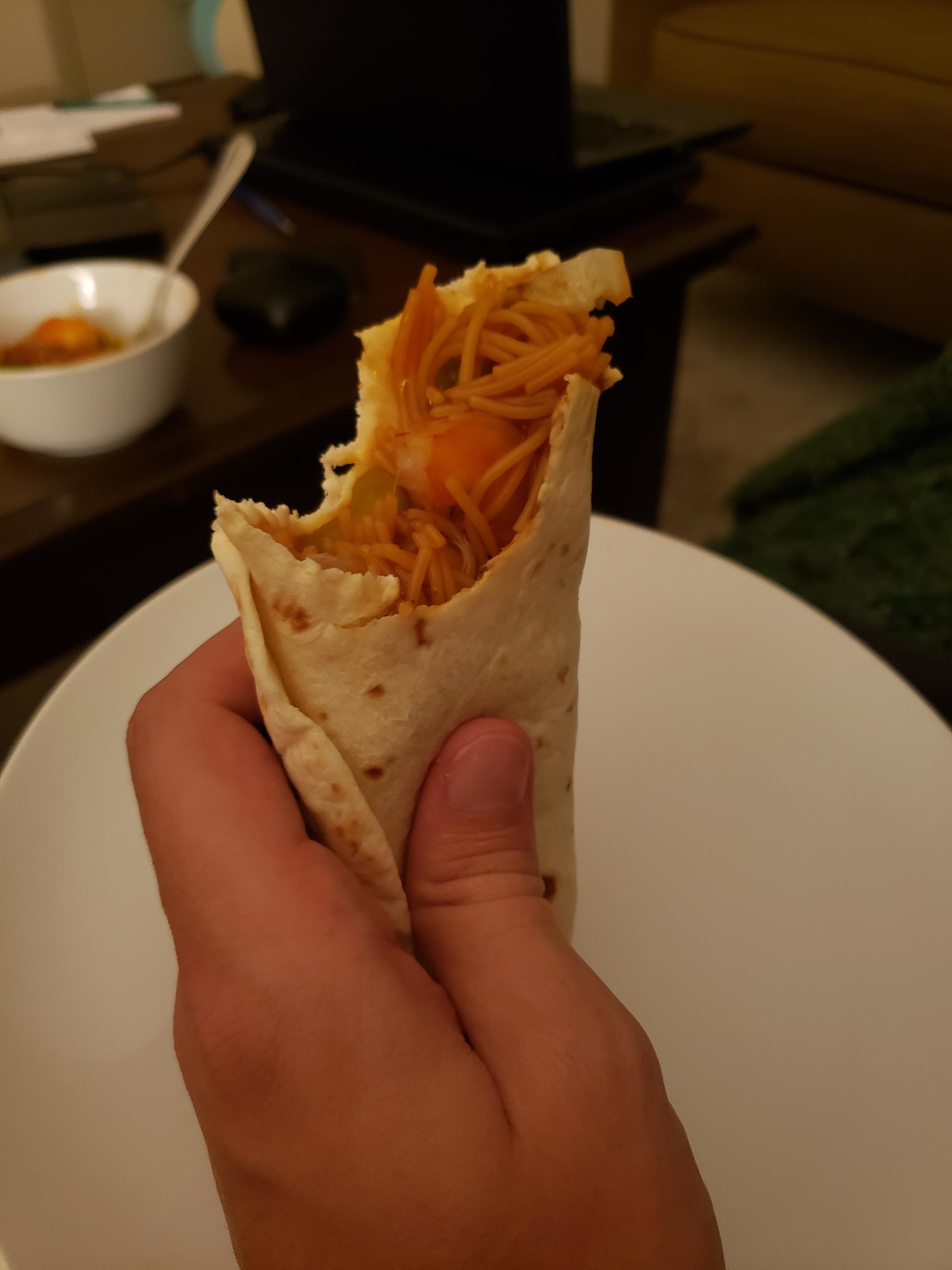 a tortilla stuffed with noodles and vegetables