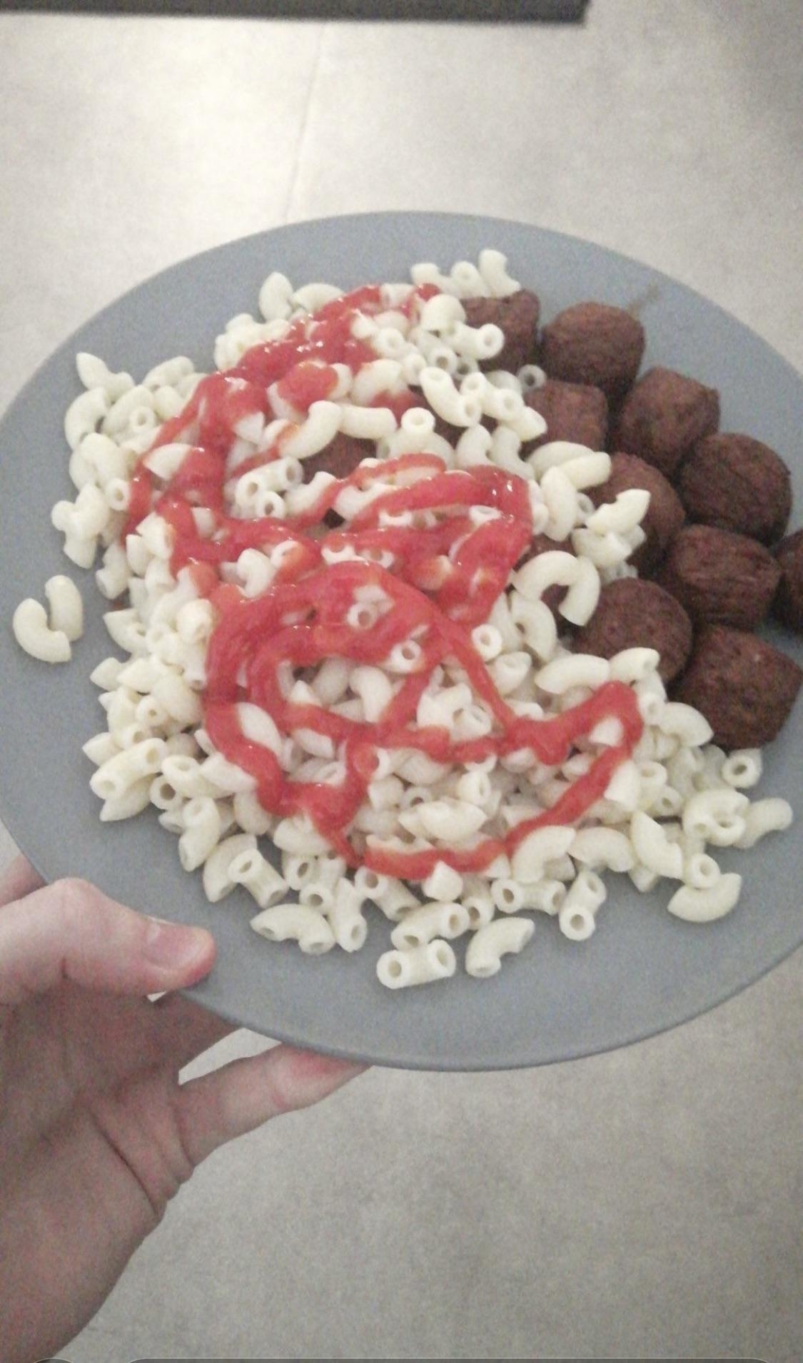 plain macaroni noodles with fish balls next to it ketchup drizzled on top