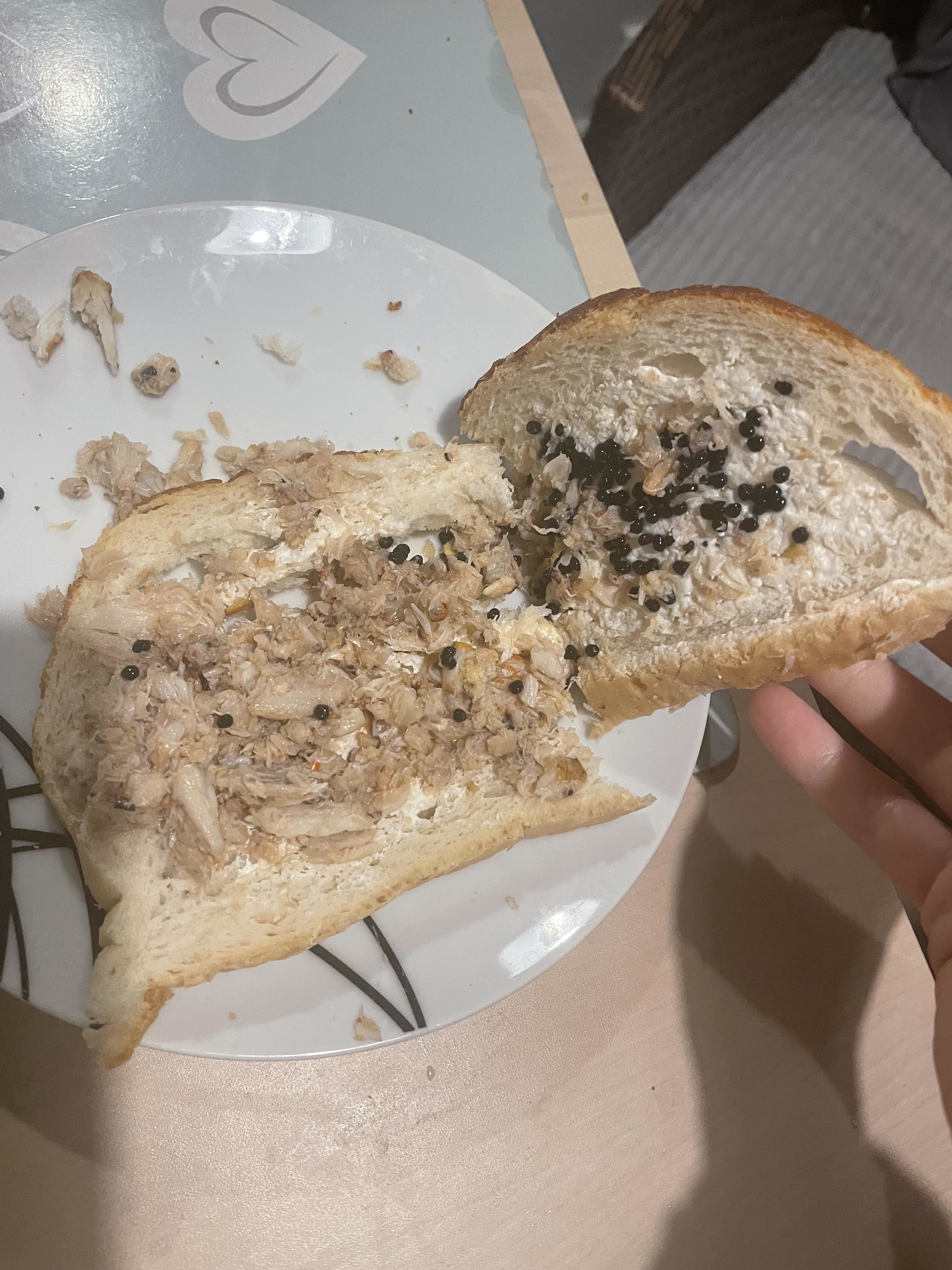white bread with canned grab meat, mayo, and caviar mashed on it