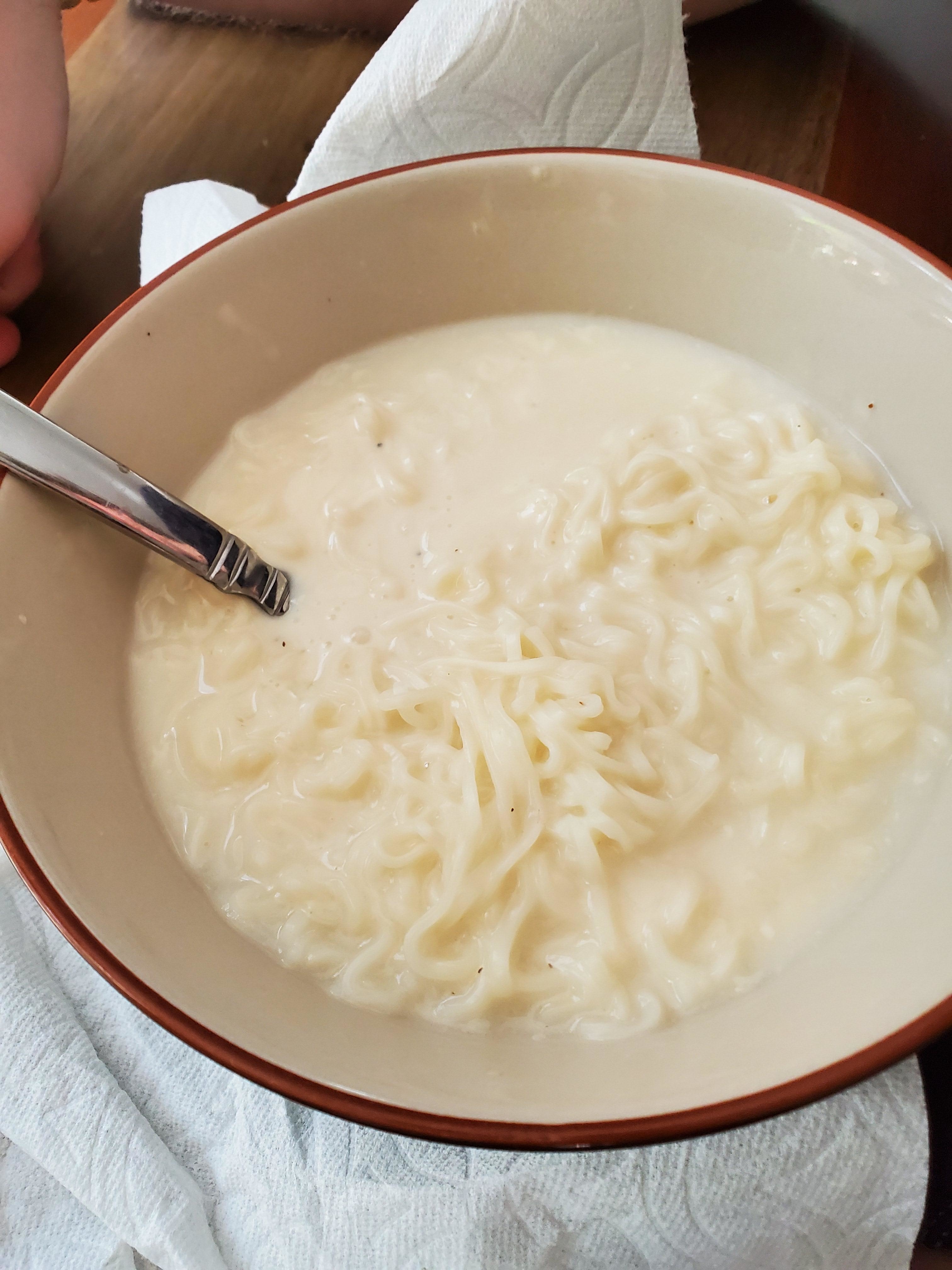 a bowl of ramen noodles in watery looking creamy soup