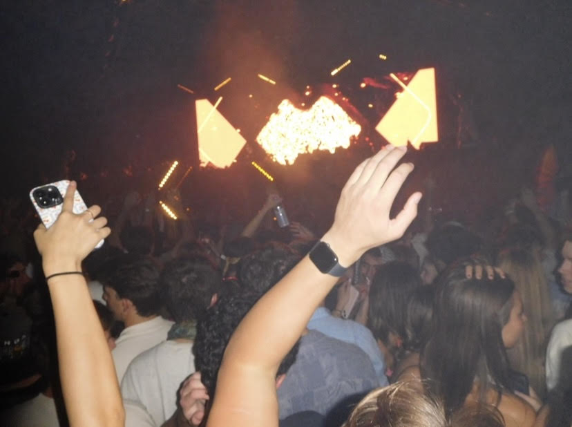 People holding their hands up in the air at a concert