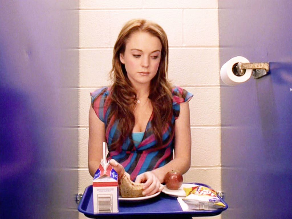 closeup of her eating her lunch in the bathroom stall