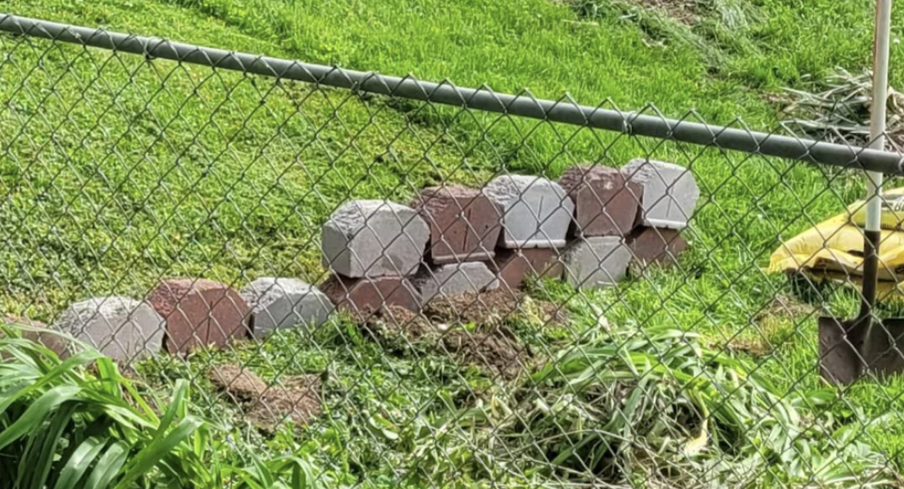 A person used patio bricks to try and build a retention wall