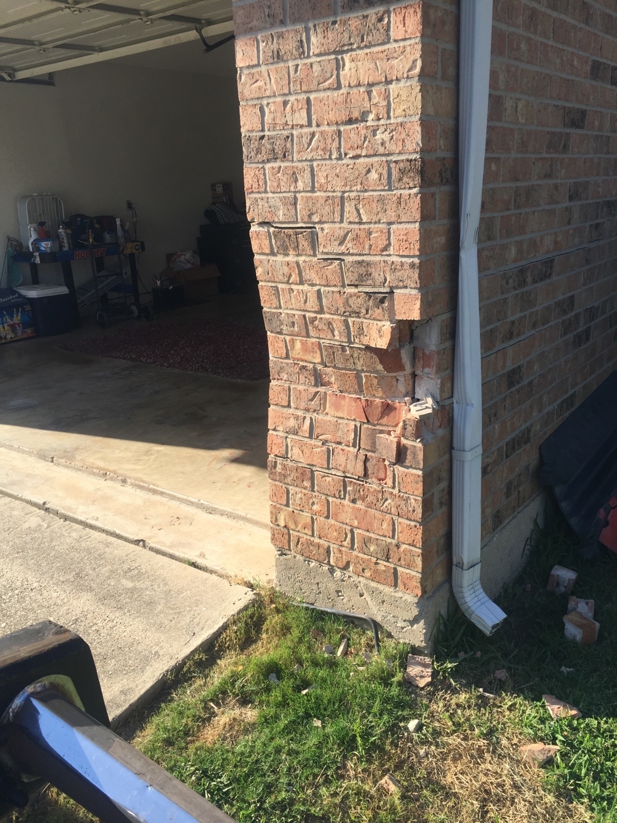 The bricks of someone&#x27;s garage completed rammed into and curved