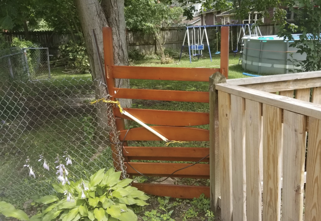 Someone used a headboard and footboard of a bed frame to fill in the hole in their fence