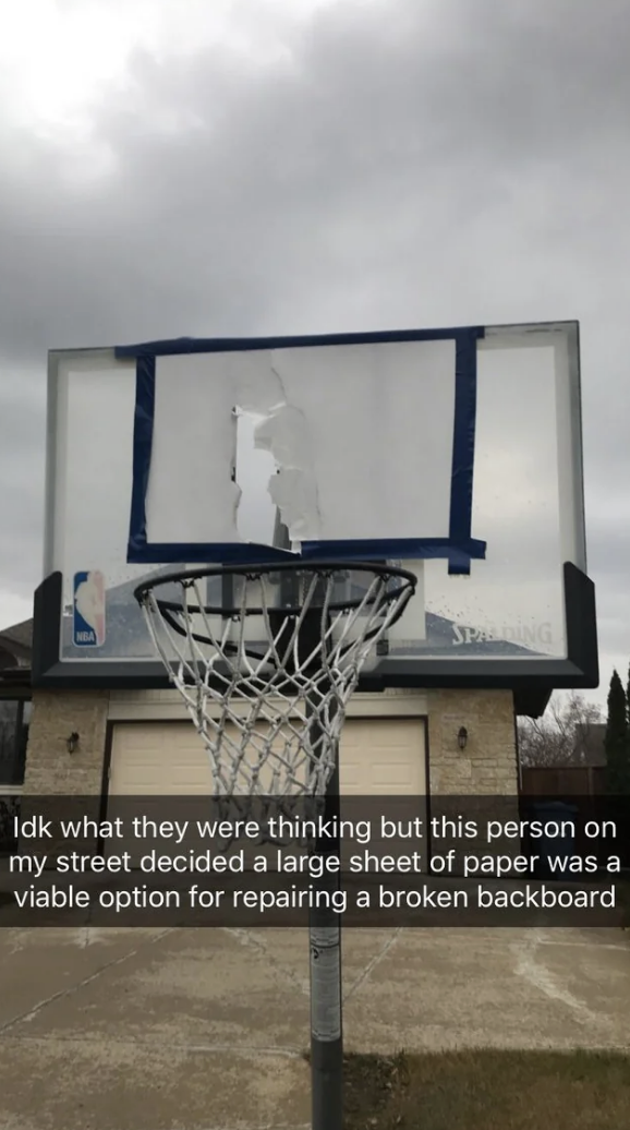 A backboard of a basketball net repaired with a piece of white paper