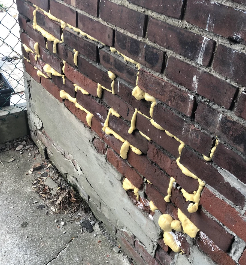 The mortar holding bricks together filled with spray foam insulation