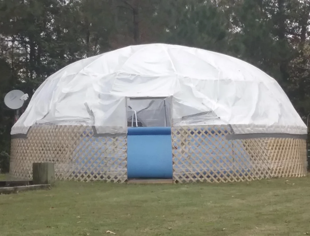 A dad made a dome cover over their blue blow up pool using garden fencing and a dome tarp
