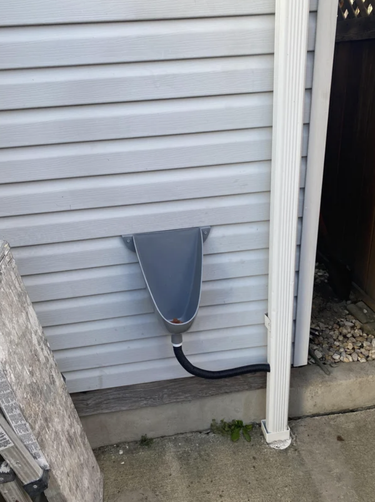 A urinal installed outside on the wall of someone&#x27;s house and drains through the rain pipes