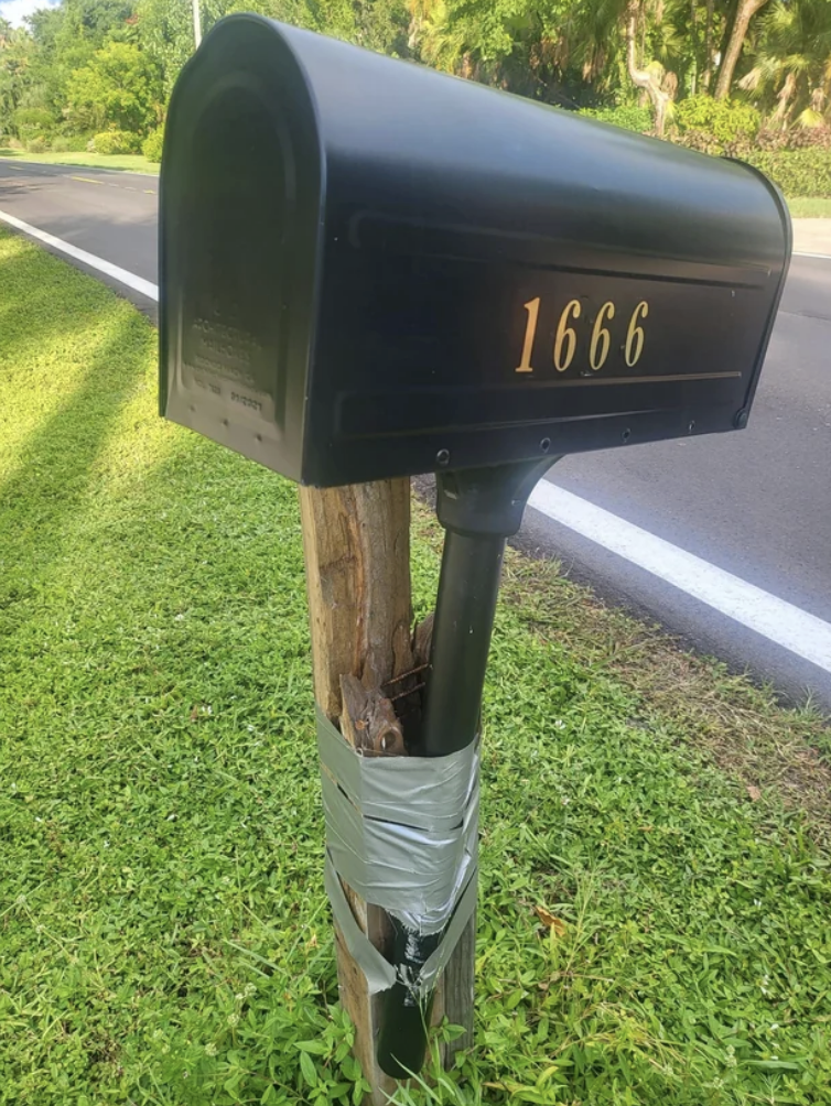 A mailbox held together with duct tape and wood