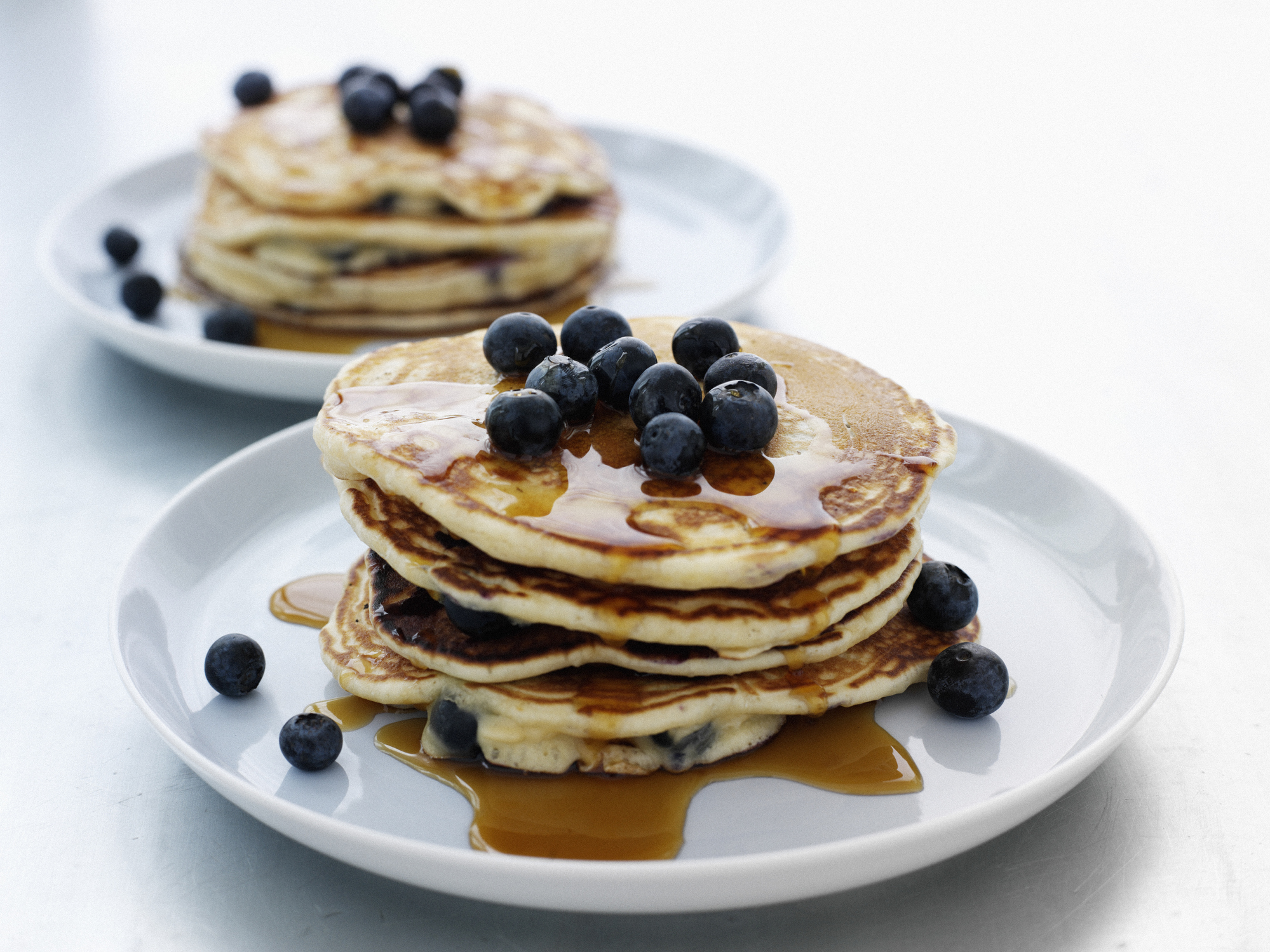 a stack of pancakes with maple syrup and blueberries
